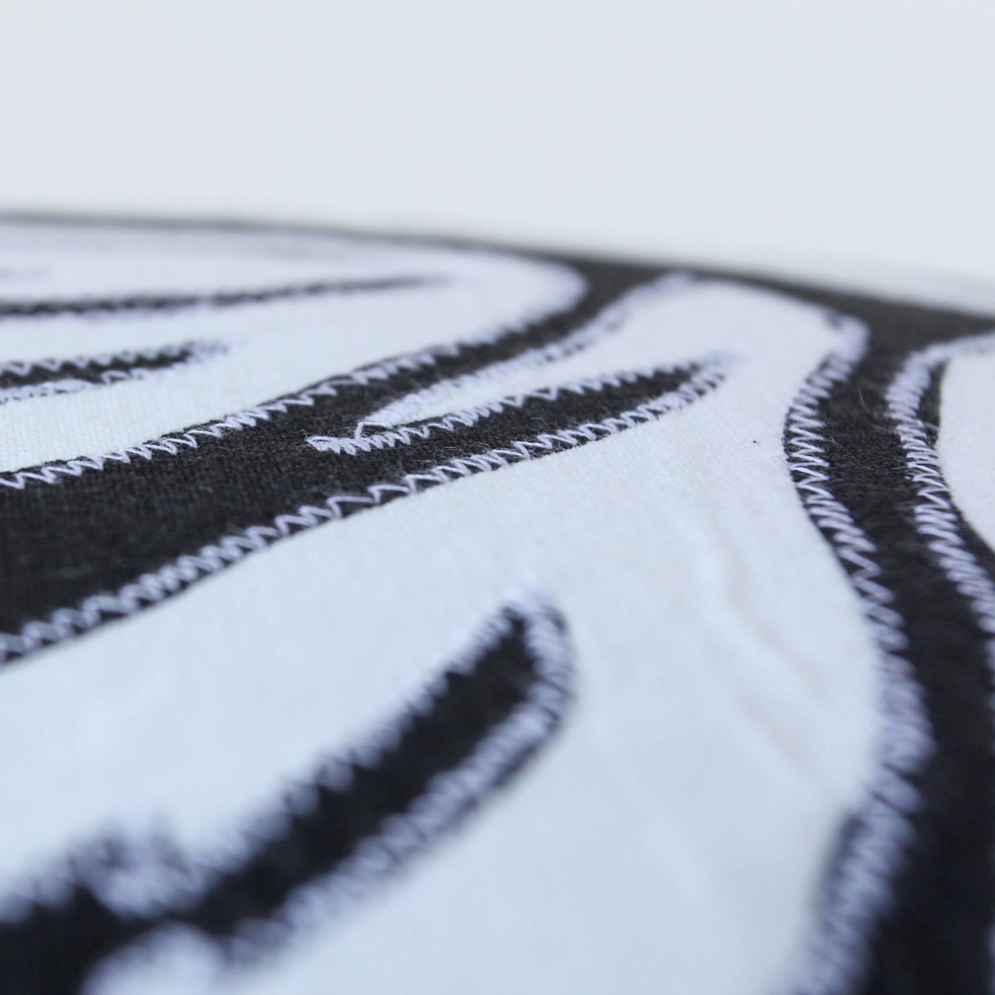 Close-up of black and white embroidered design on fabric