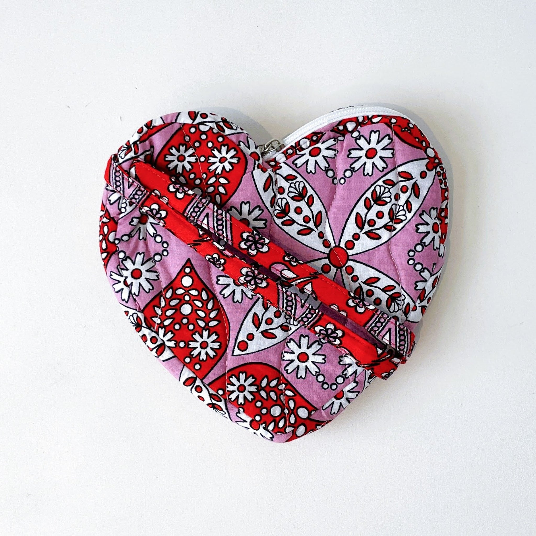 Heart-shaped pouch with red and pink pattern on a white background