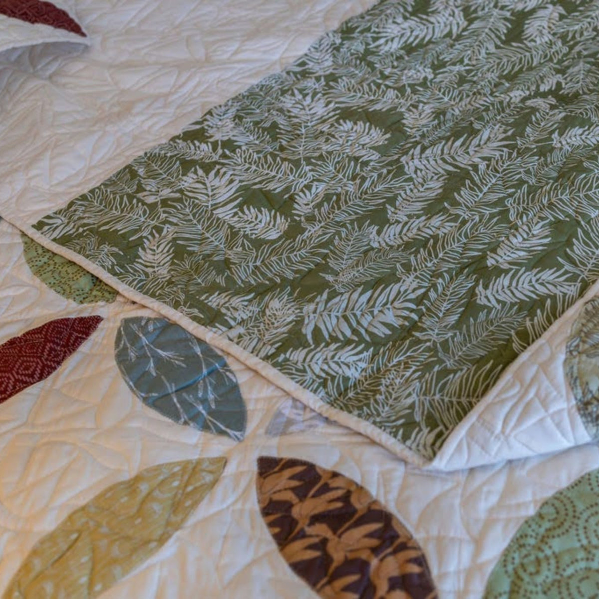 Detail of a petal quilt with green fern backing.