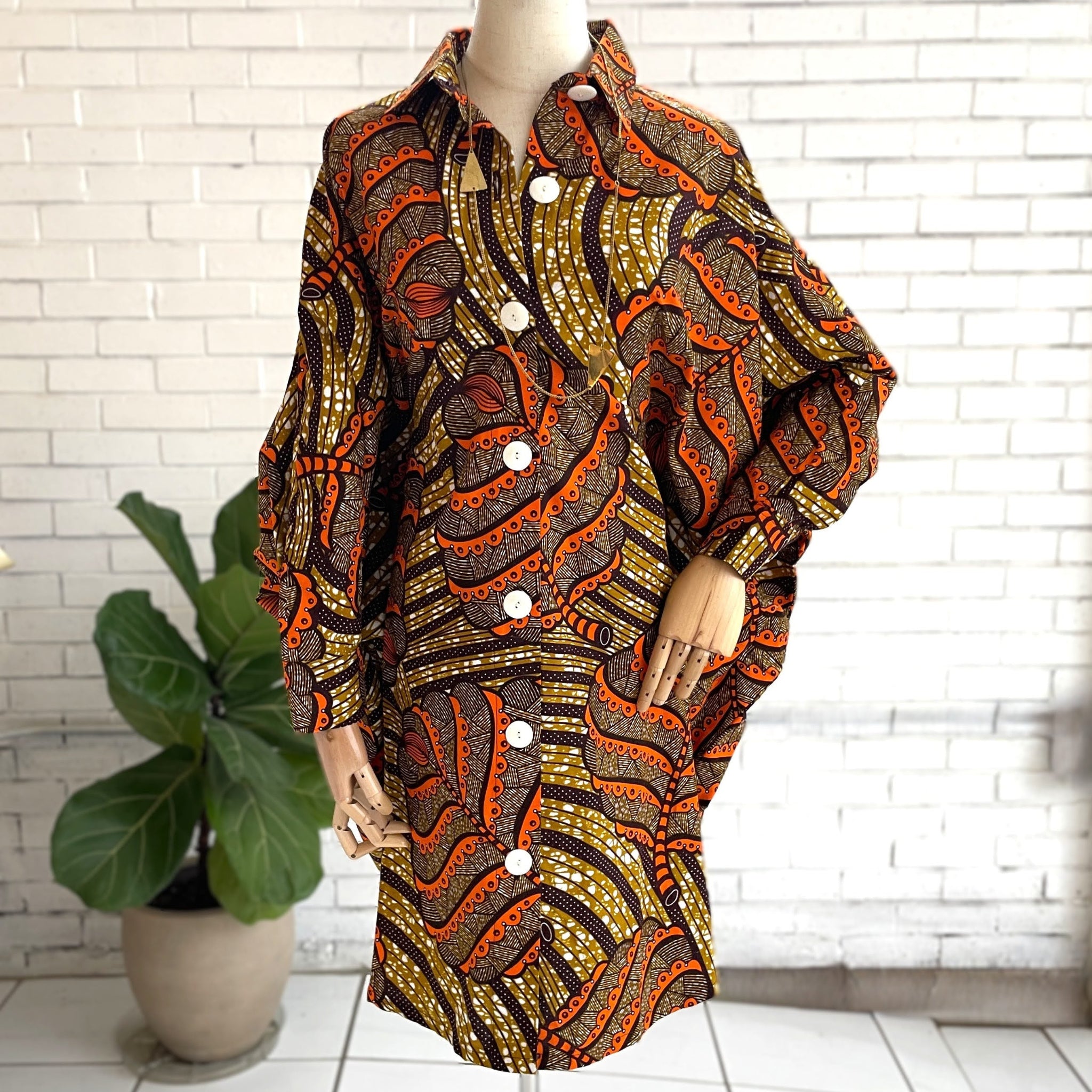 Mannequin wearing a patterned dress with a white brick wall background