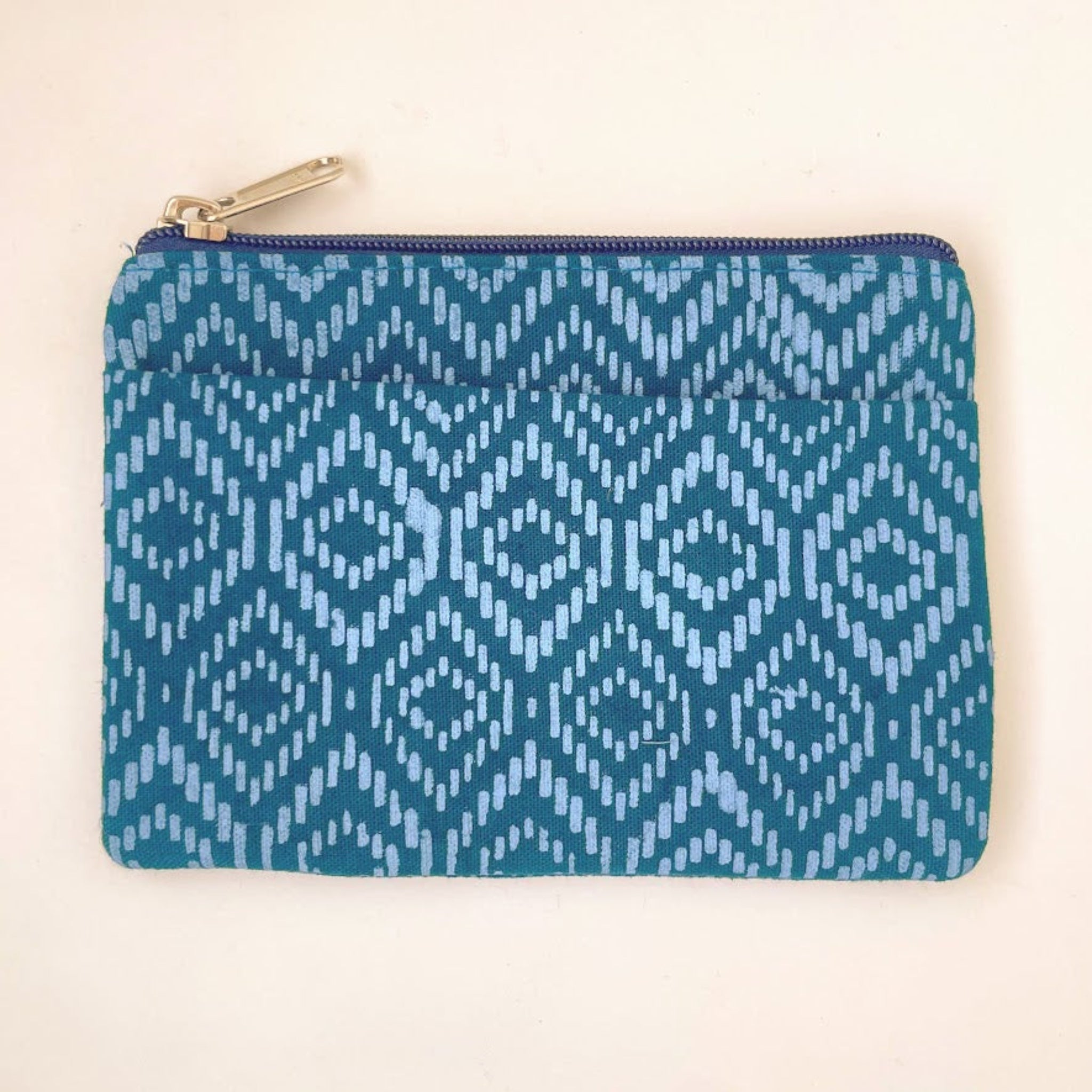 Blue patterned pouch on a beige background