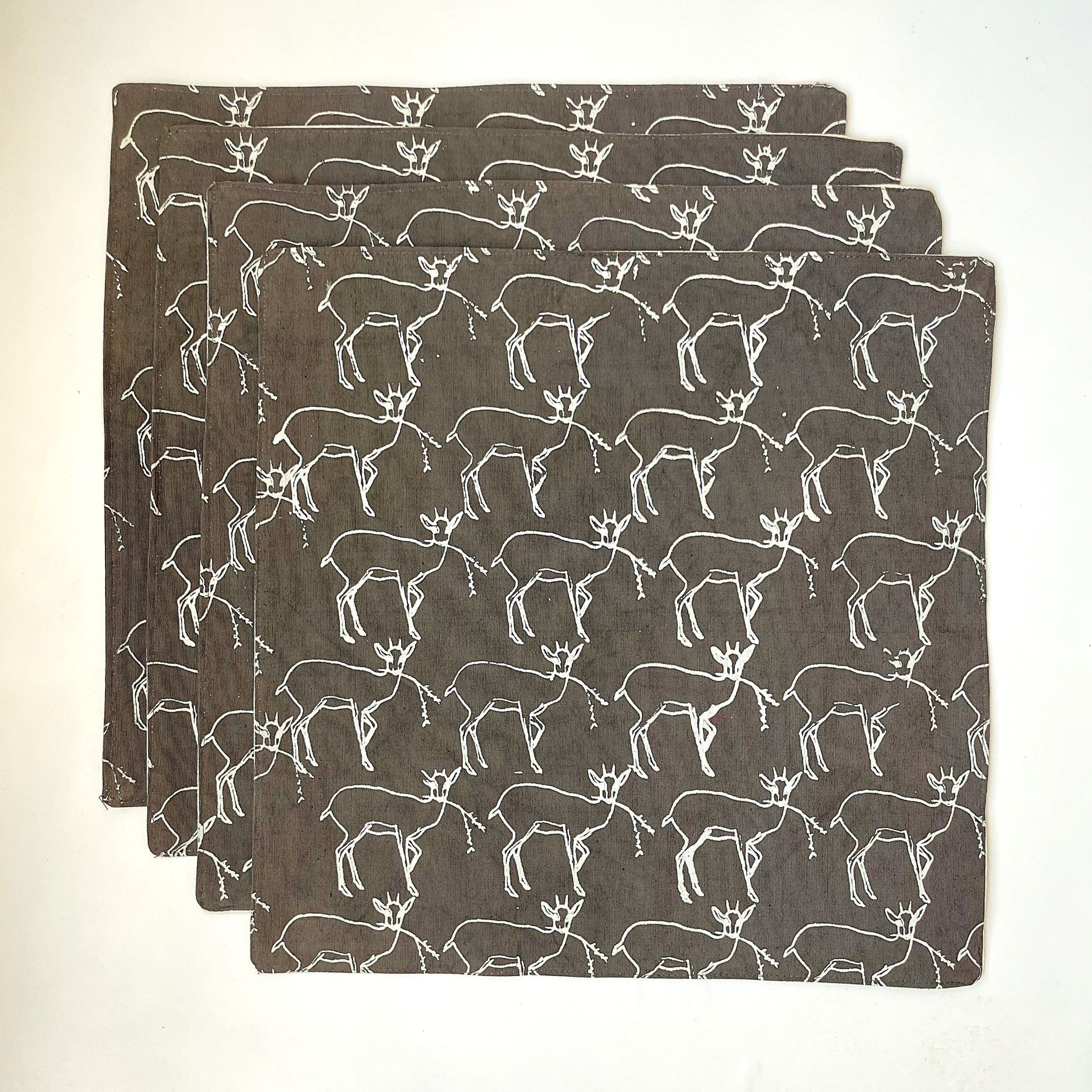 Set of four placemats with deer pattern on a gray background