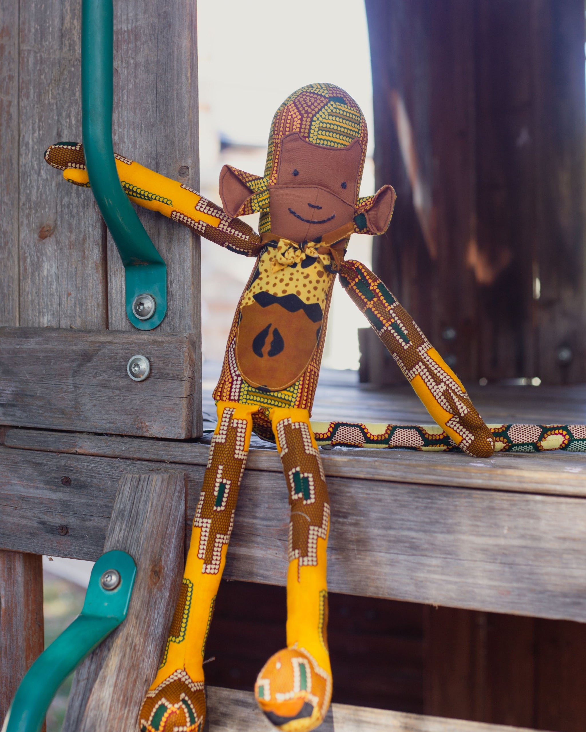 Brown and gold stuffed monkey on wooden platform