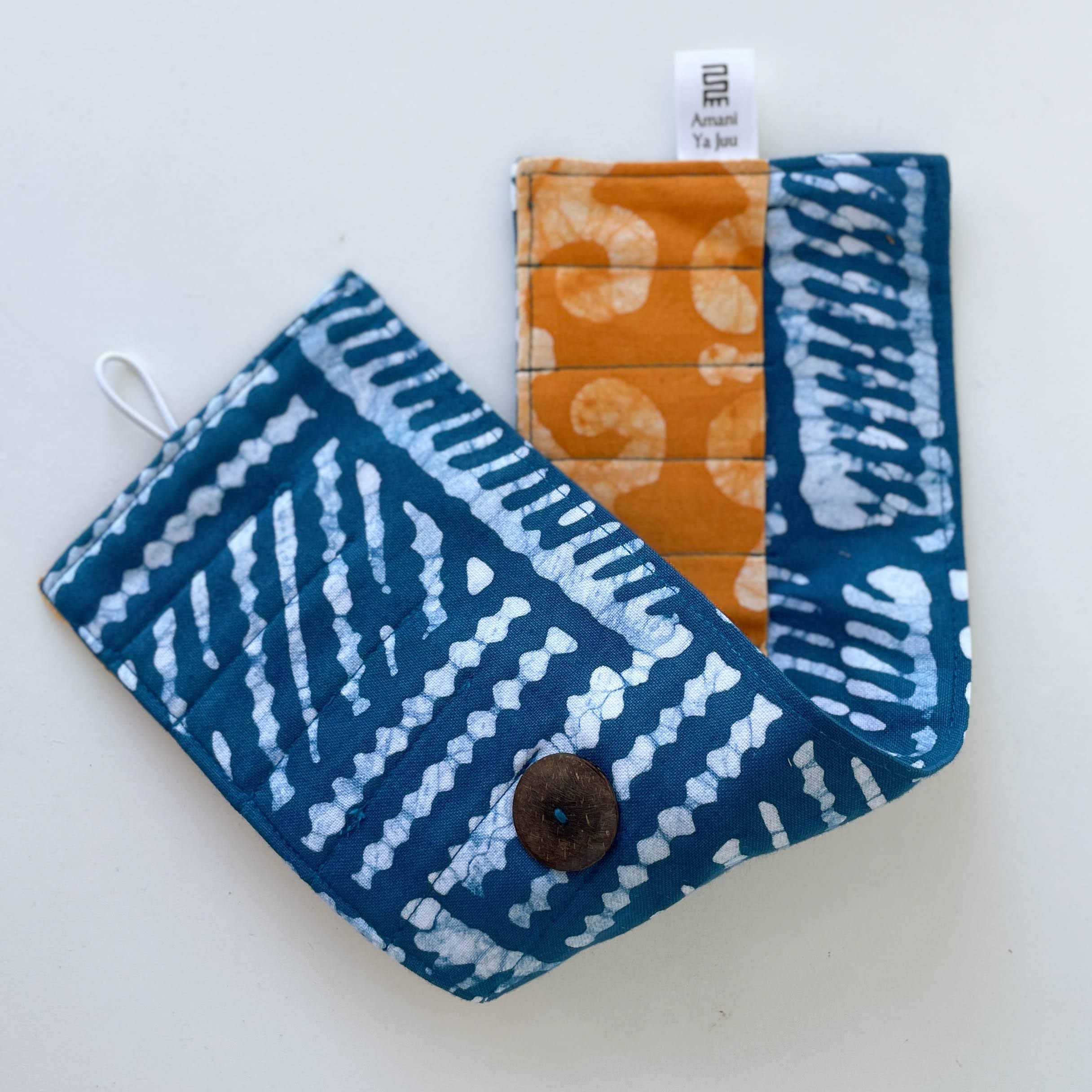 Fabric crayon holder pouch with button and tag on a light gray background