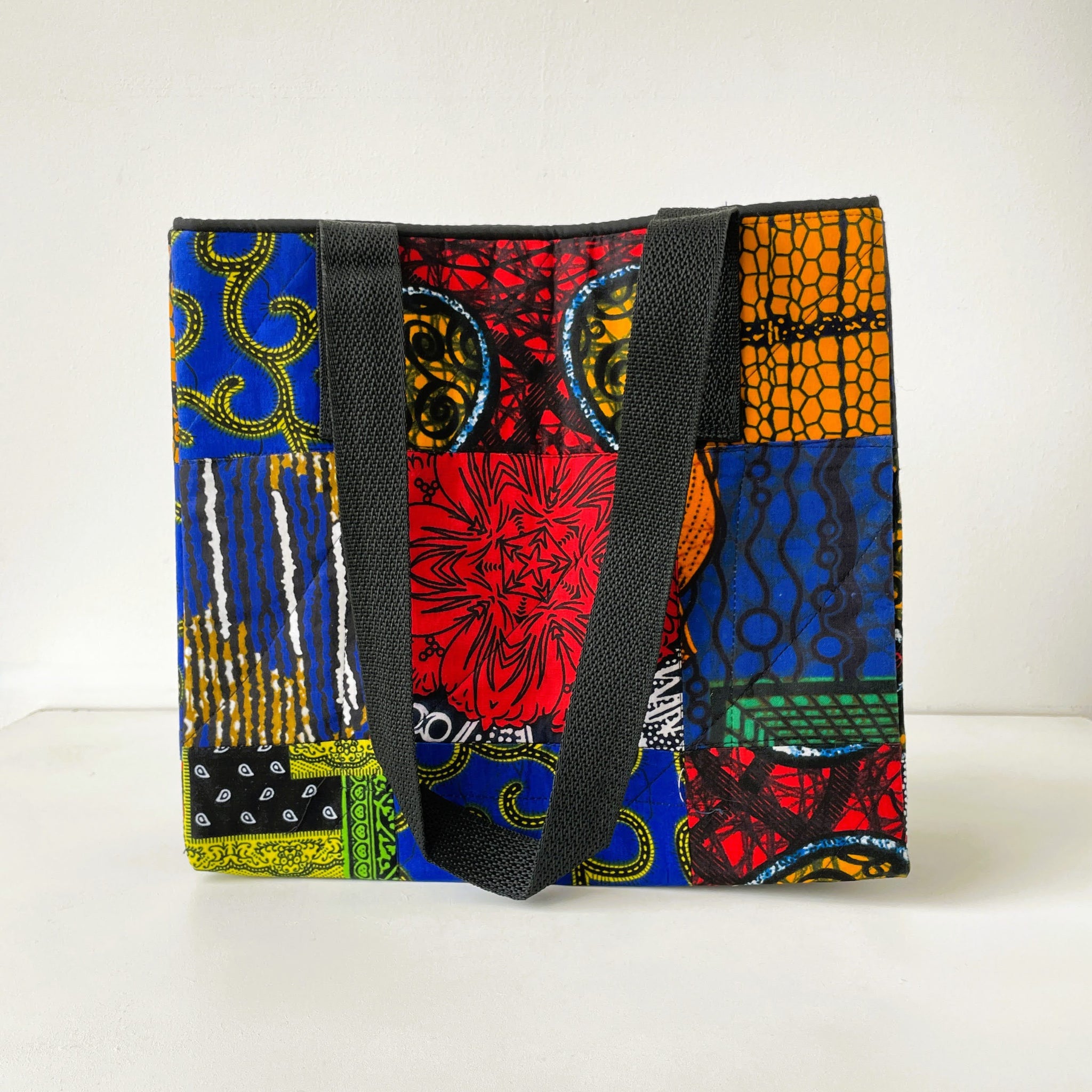 Colorful fabric bag with a patterned design on a white background