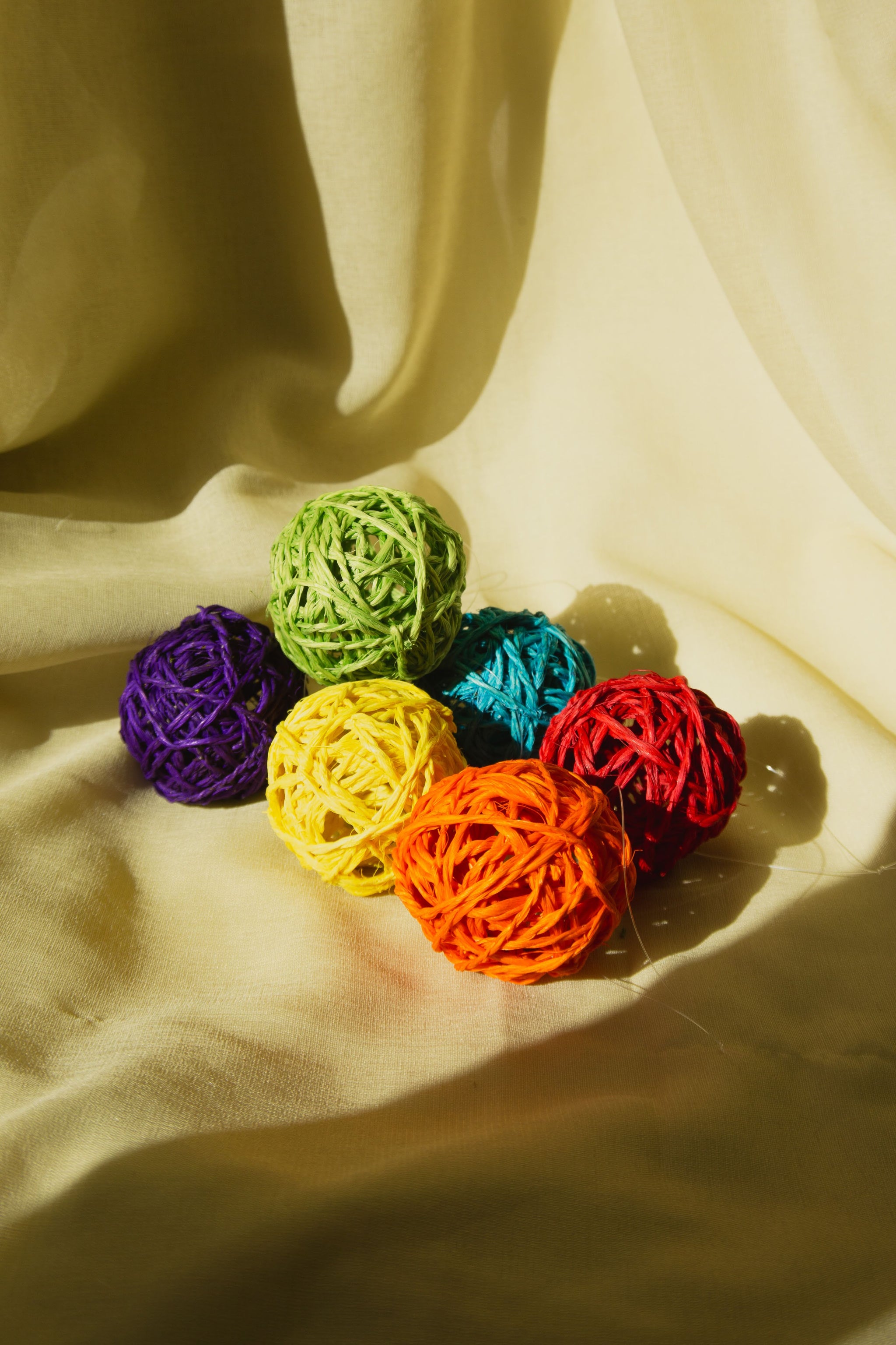 Colorful woven balls on a beige fabric background
