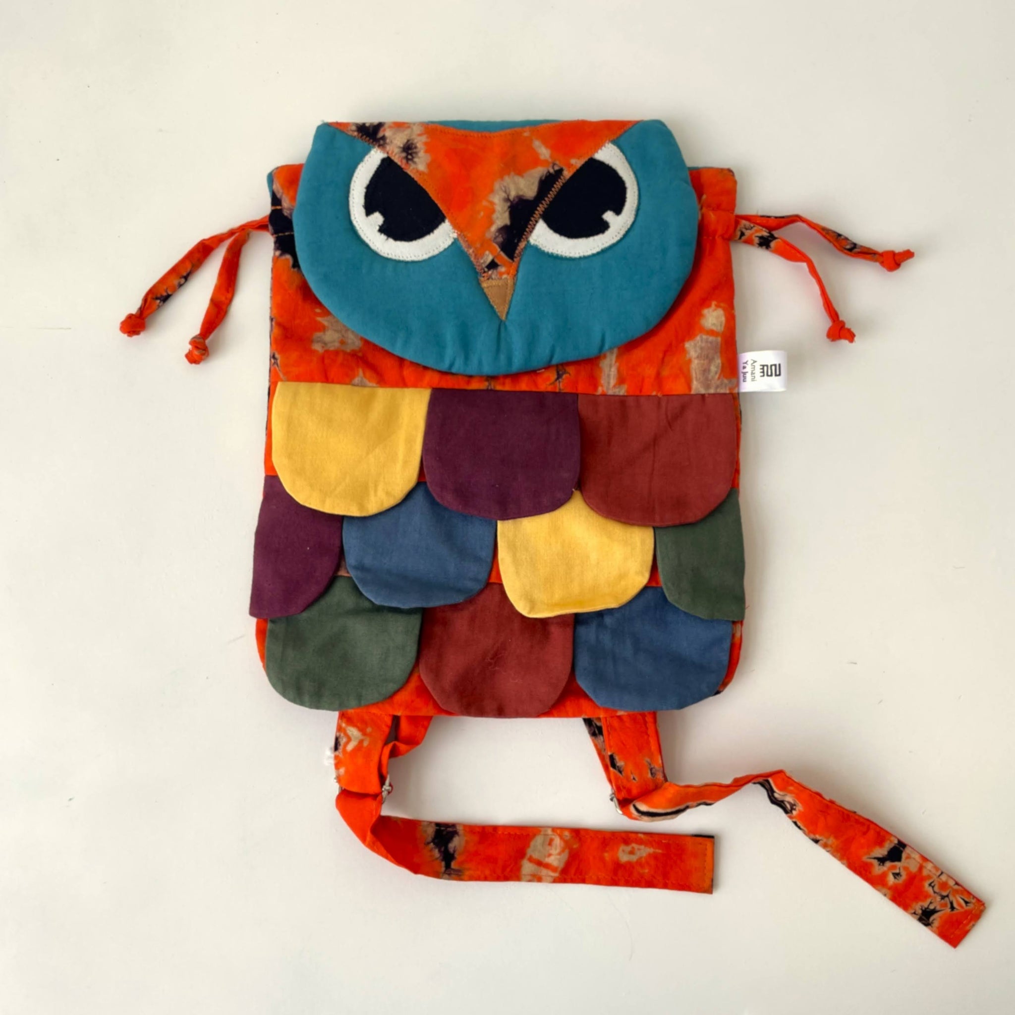 Colorful owl-shaped backpack with a strap on a white background