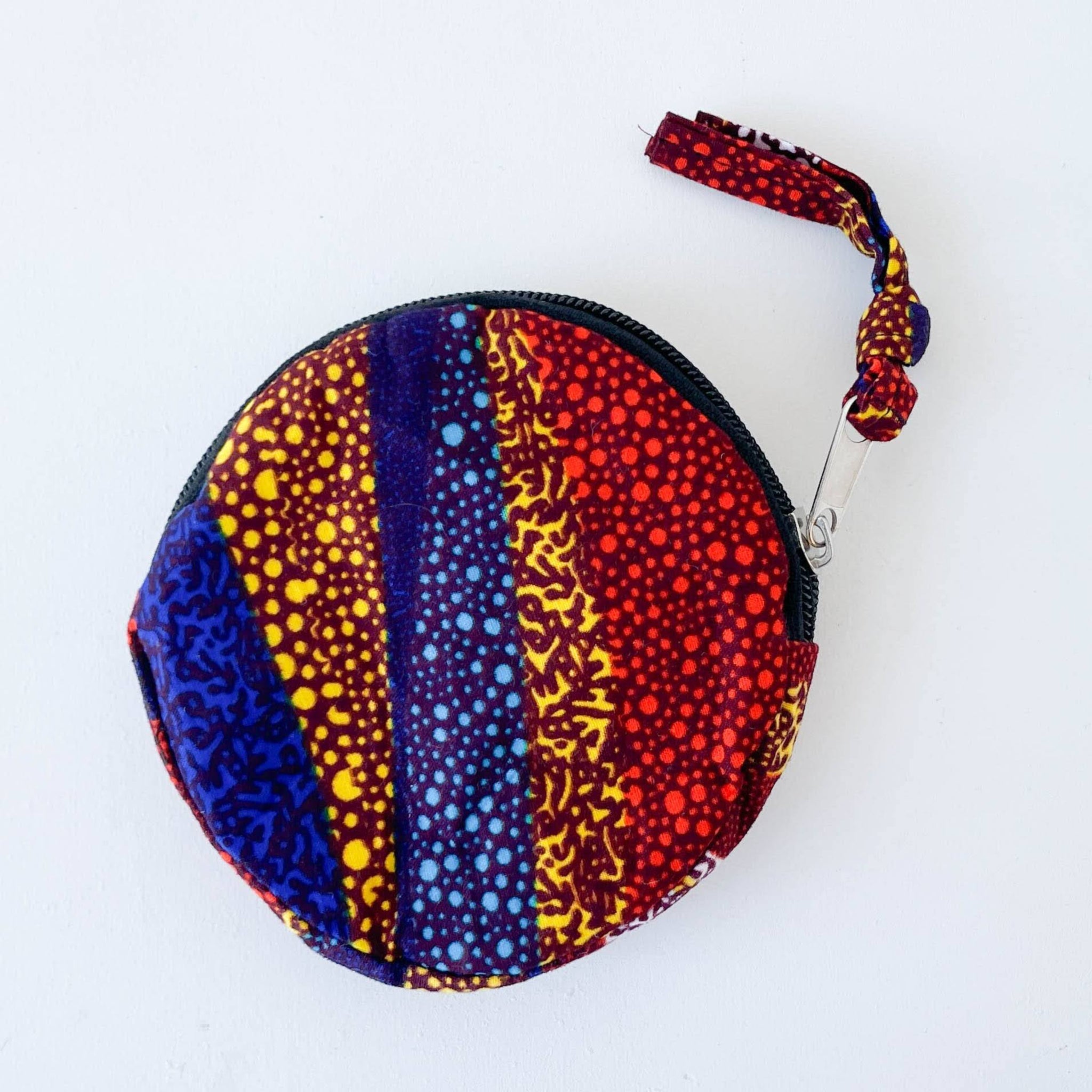 Round colorful pouch with patterned design on a white background