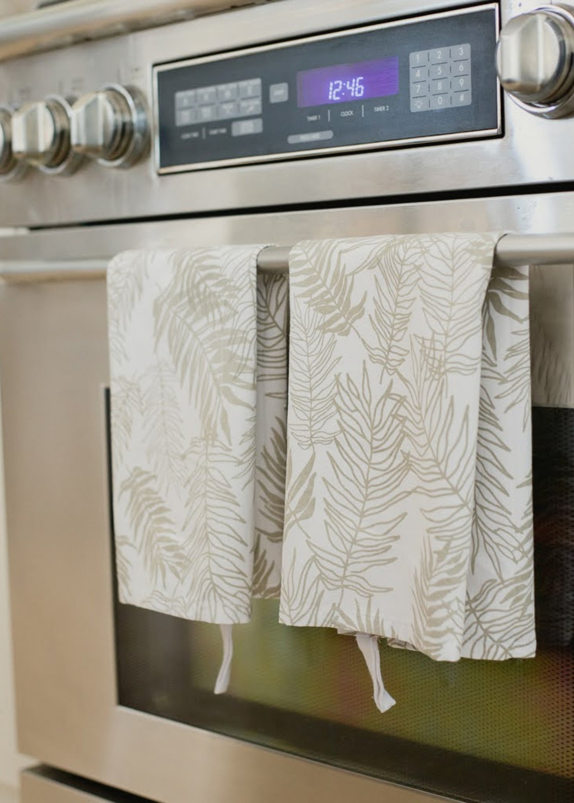 Stainless steel oven with patterned towels hanging on the handle