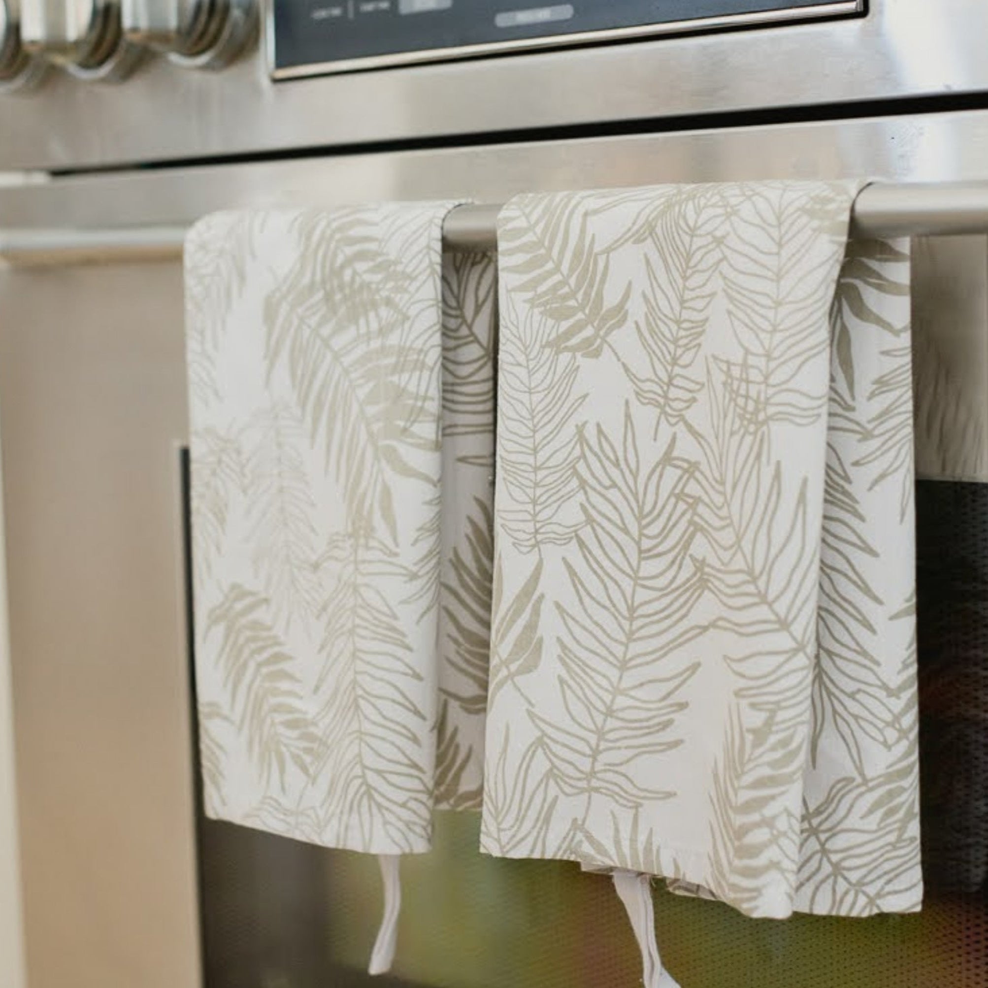 Stainless steel oven with patterned towels hanging on the handle