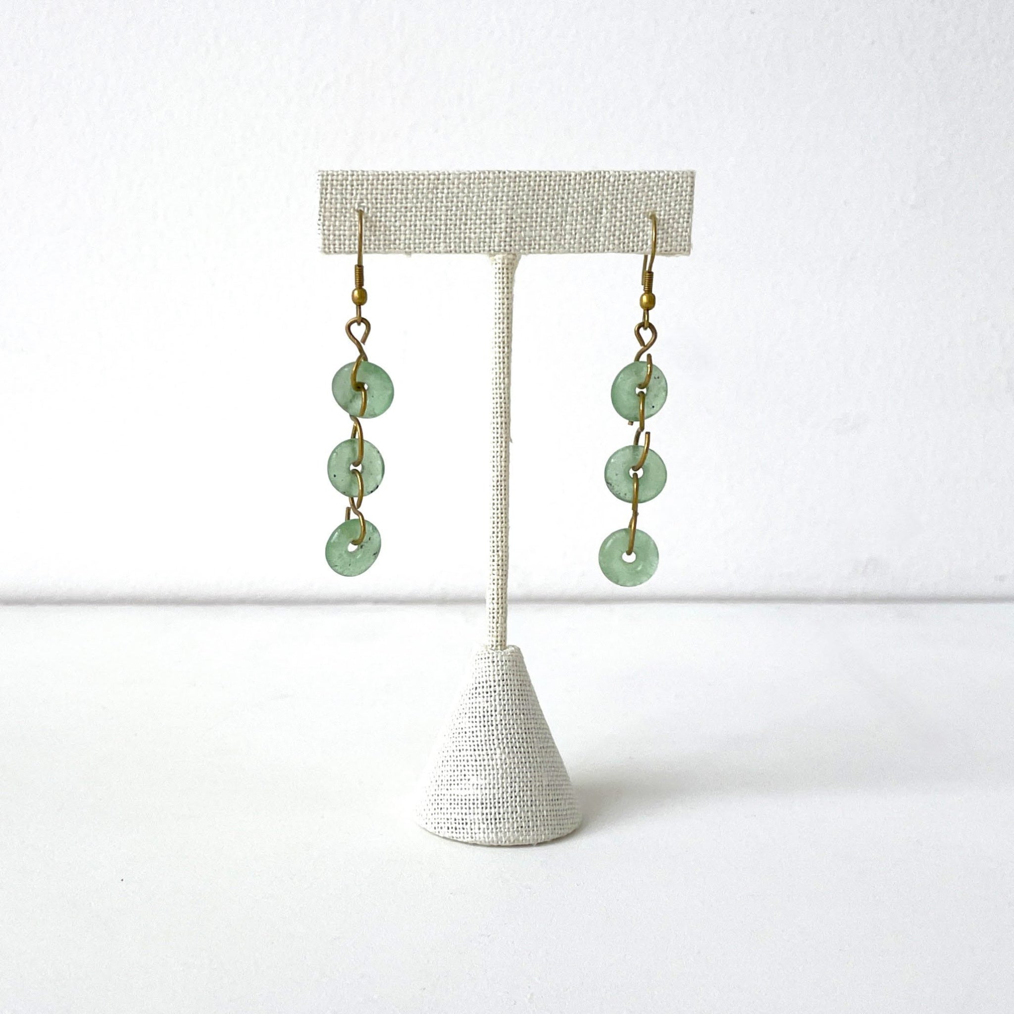 Pair of pale green glass earrings on a white background