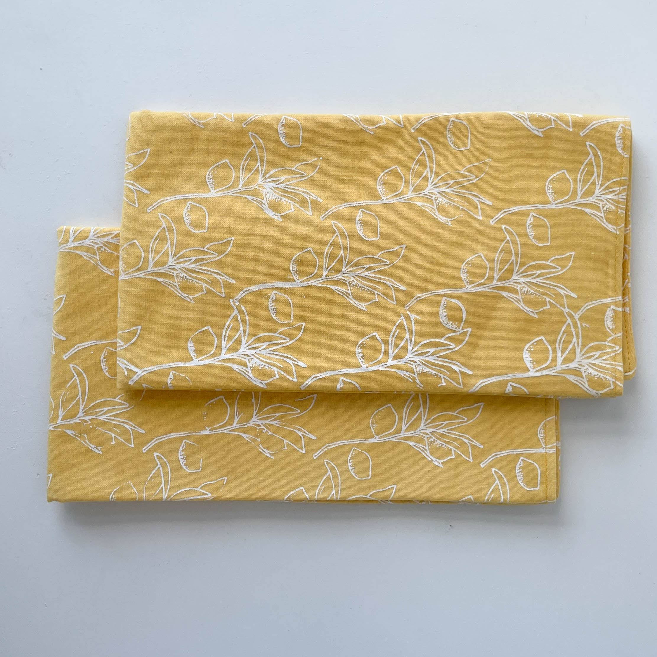 Yellow fabric with white floral pattern on a light gray background