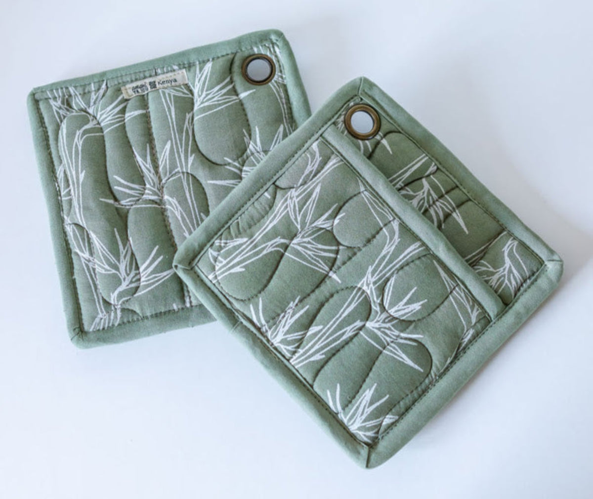 Pair of green floral pot holders on white background
