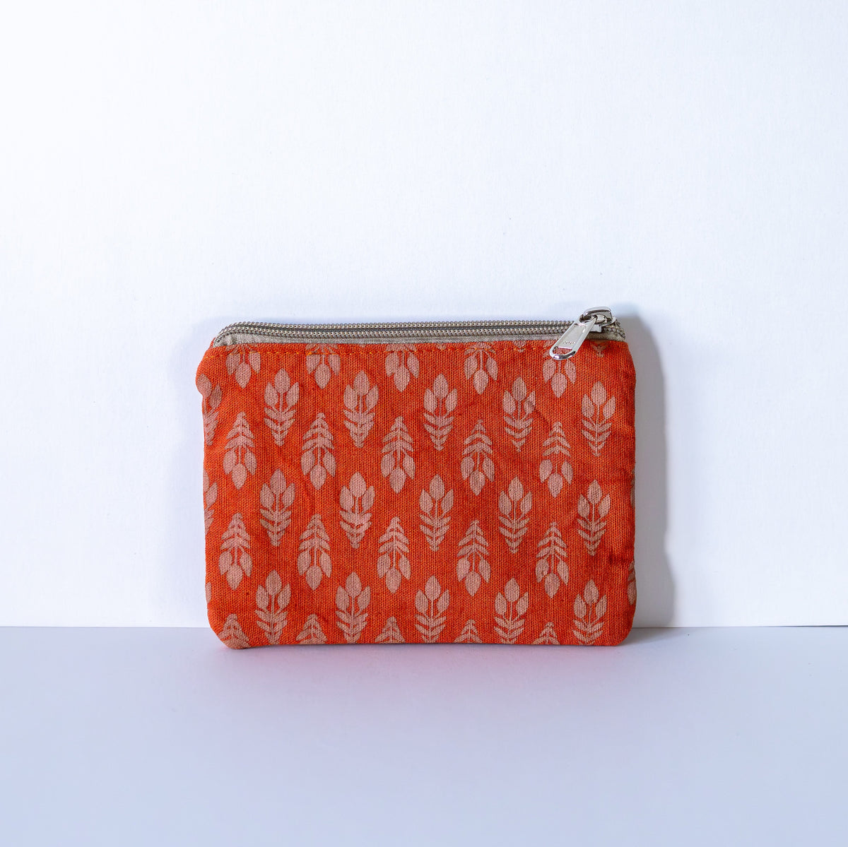 Orange floral coin purse on a white background