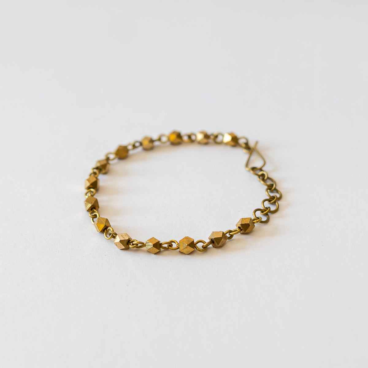 Bracelet made of faceted brass beads on a white surface