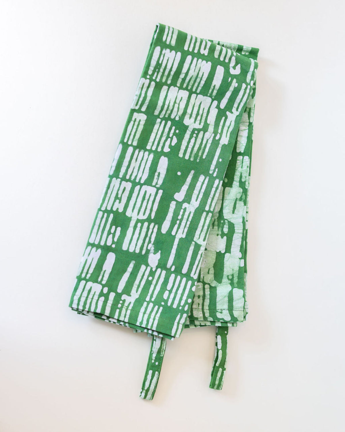 Set of green and white striped dish towels with hanging loop on a white surface