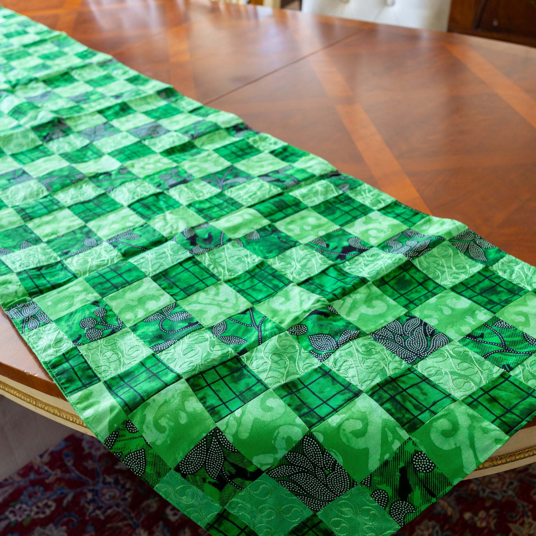 Green patchwork table runner on wooden table