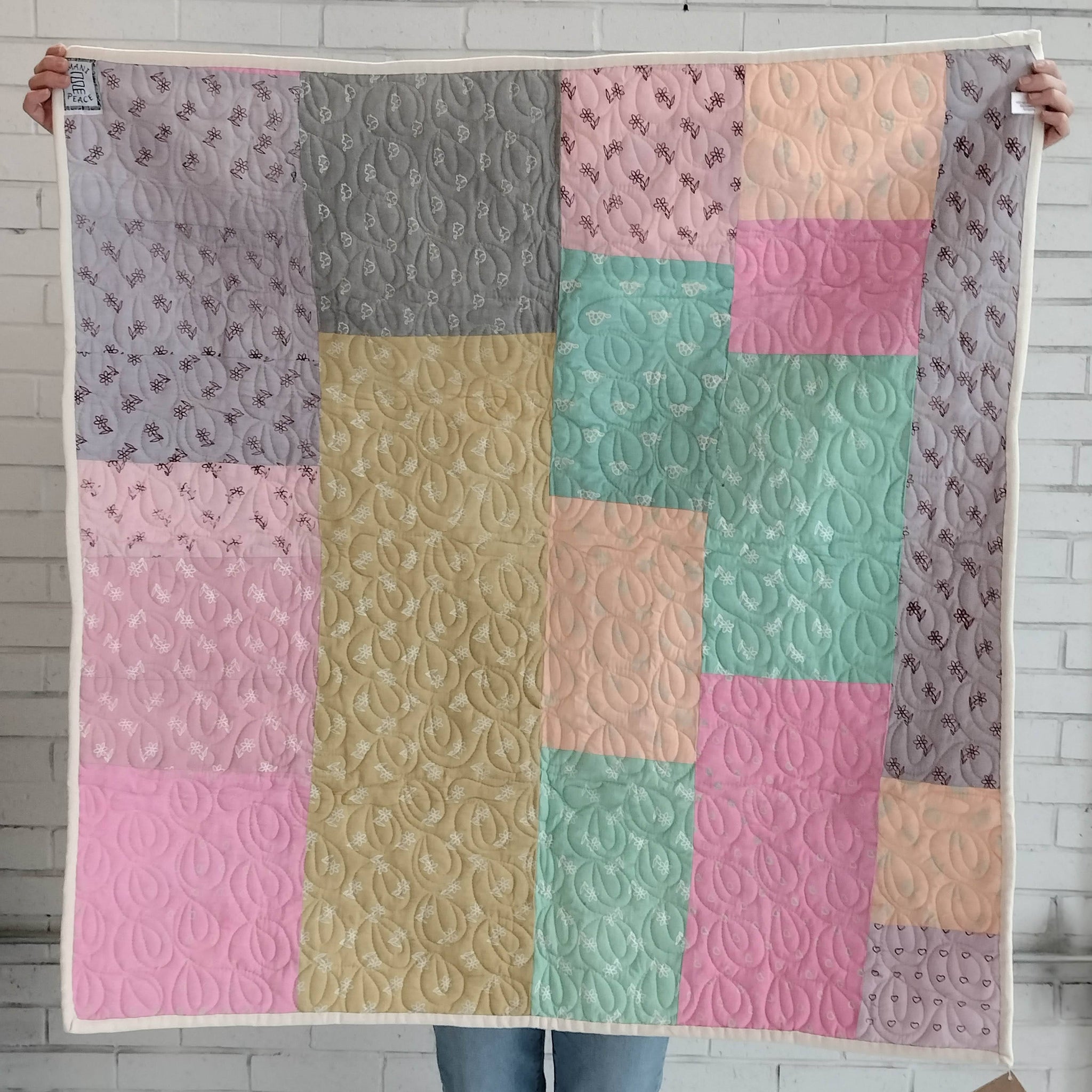 Hand stitched, hand dyed fabrics pieced together for an Amani ya Juu baby quilt