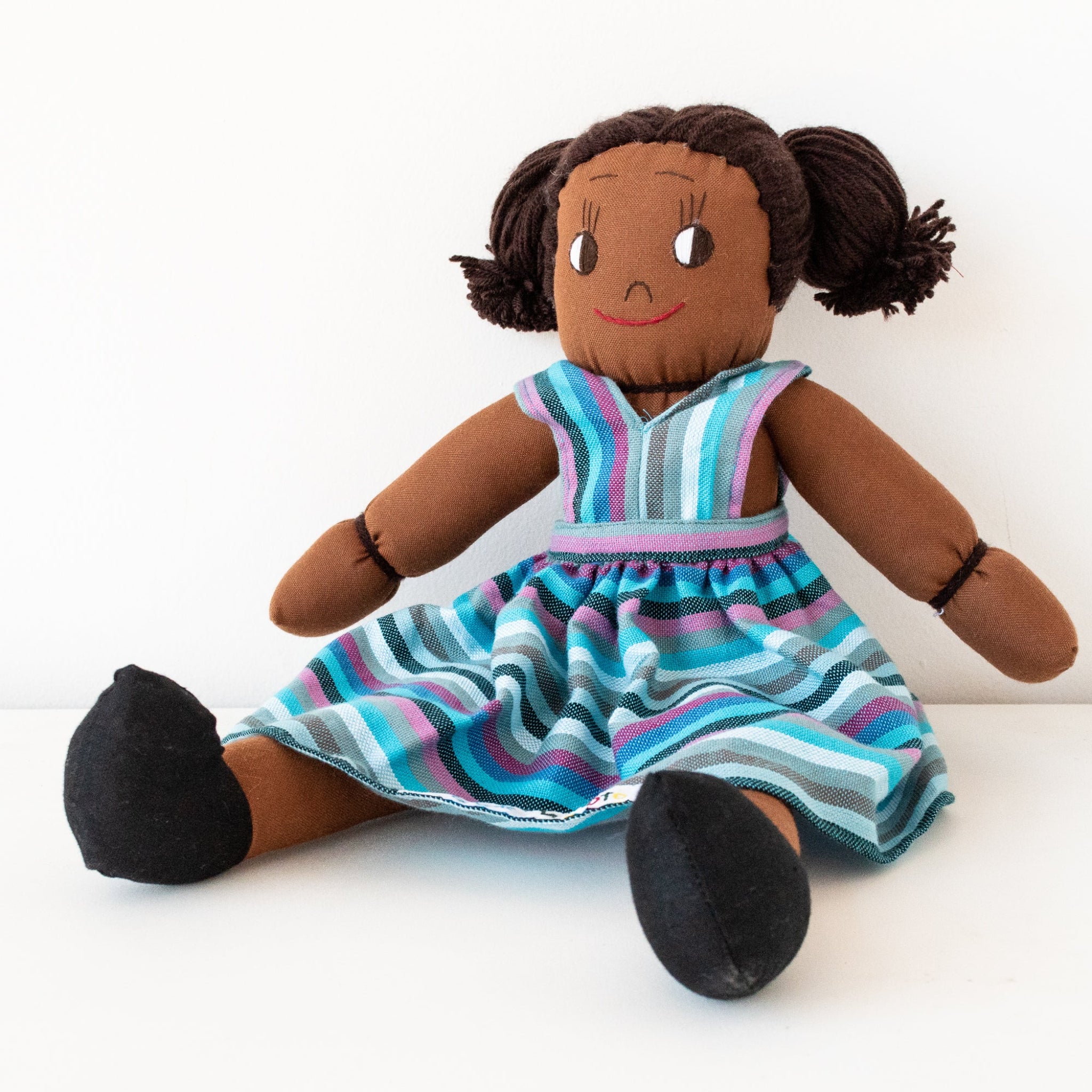 Plush doll with a striped dress on a white background
