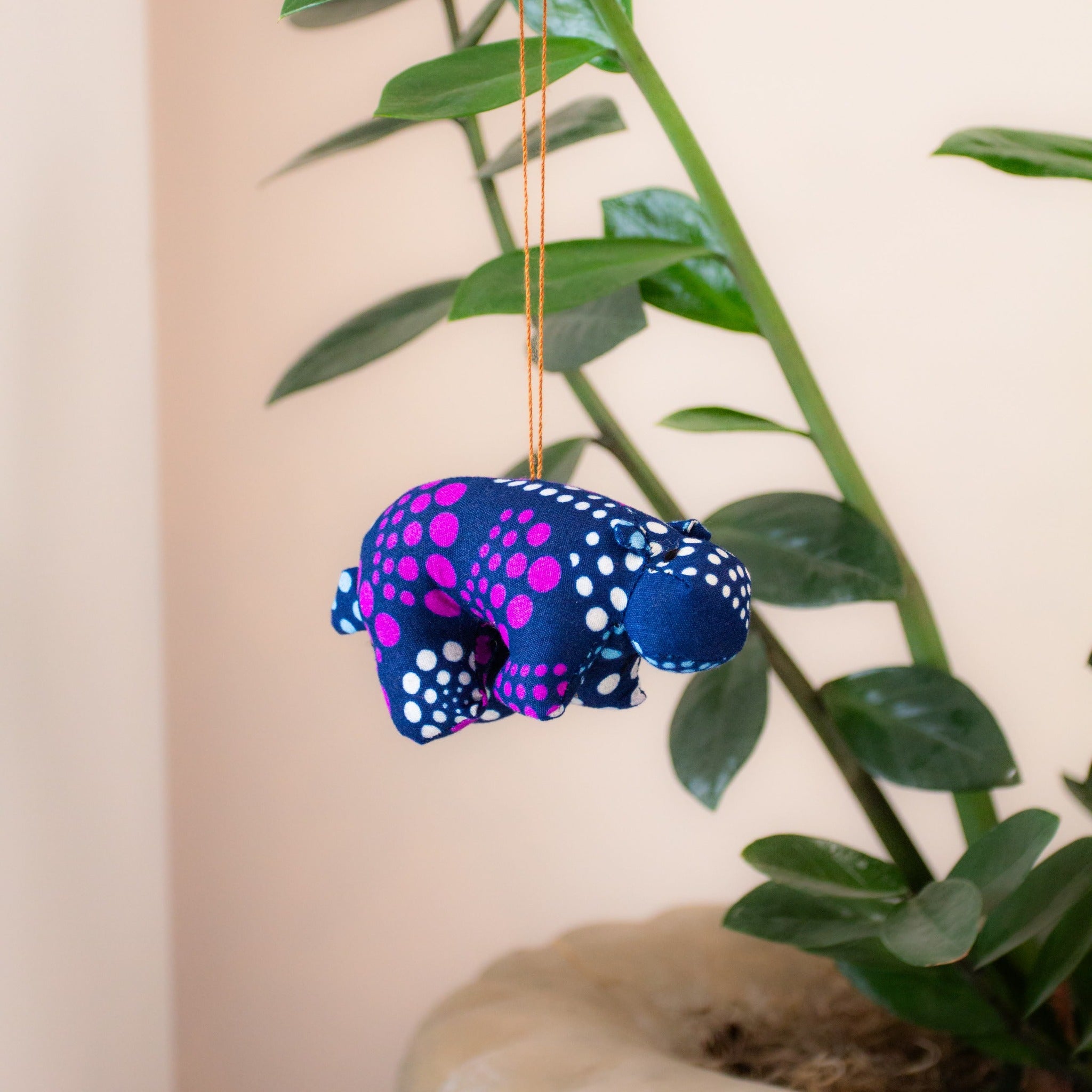 Stuffed hippo ornament hanging on a tree