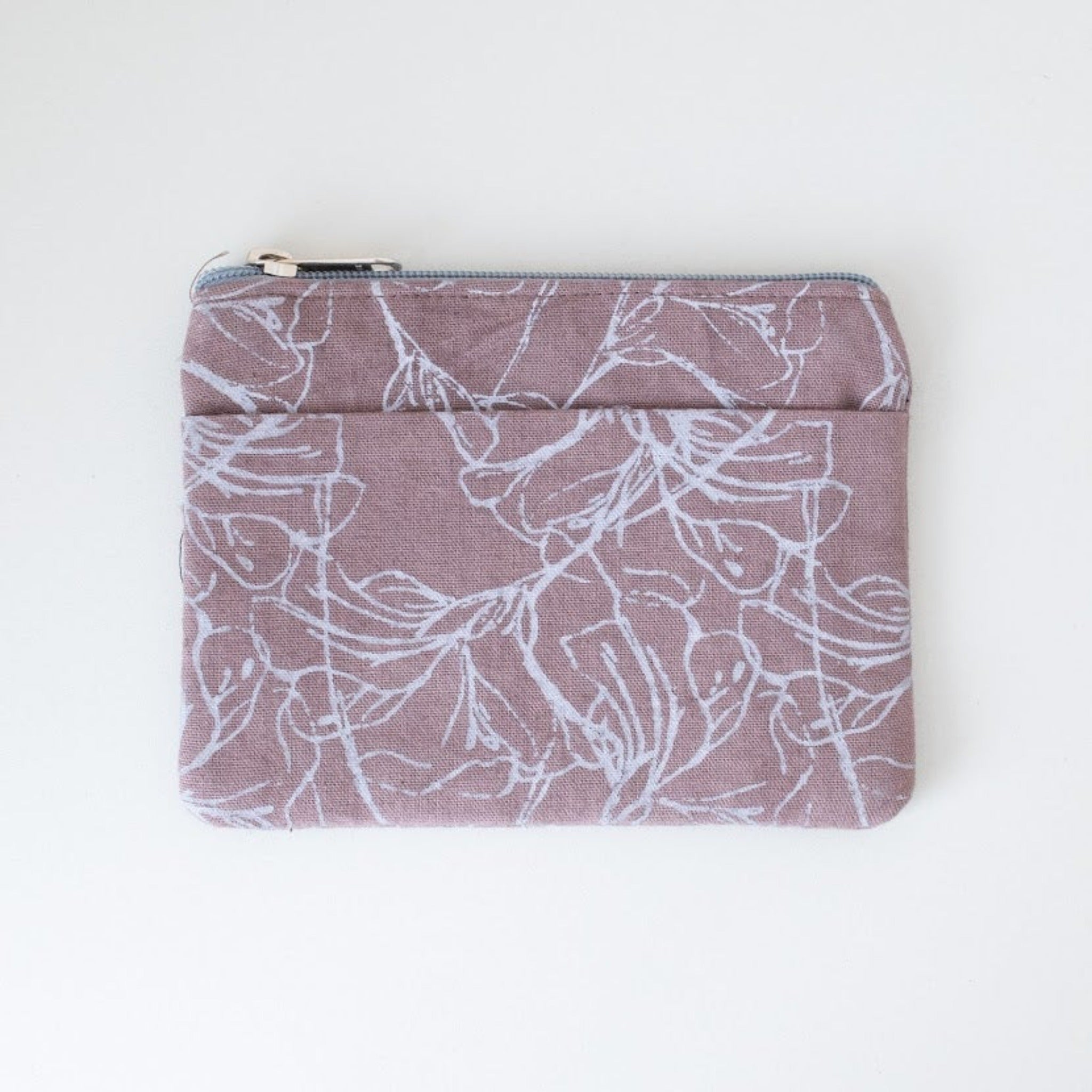 Orchid colored coin purse with floral pattern on a white background.