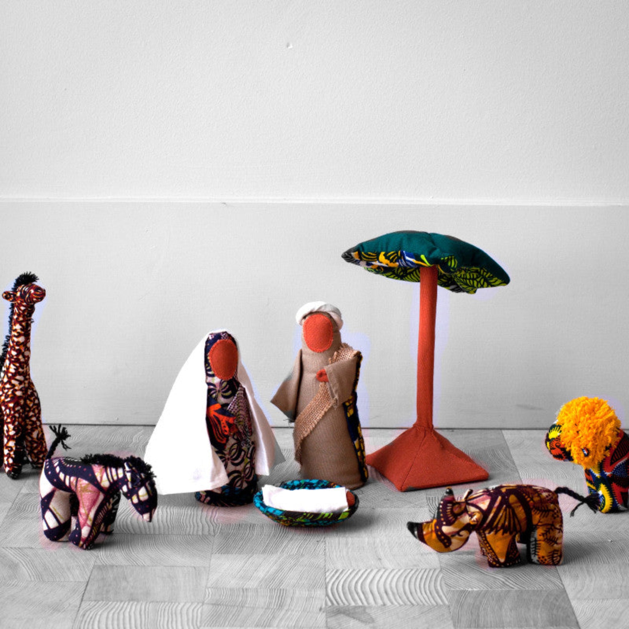 Set of colorful fabric dolls and animals on a light gray surface with a white background