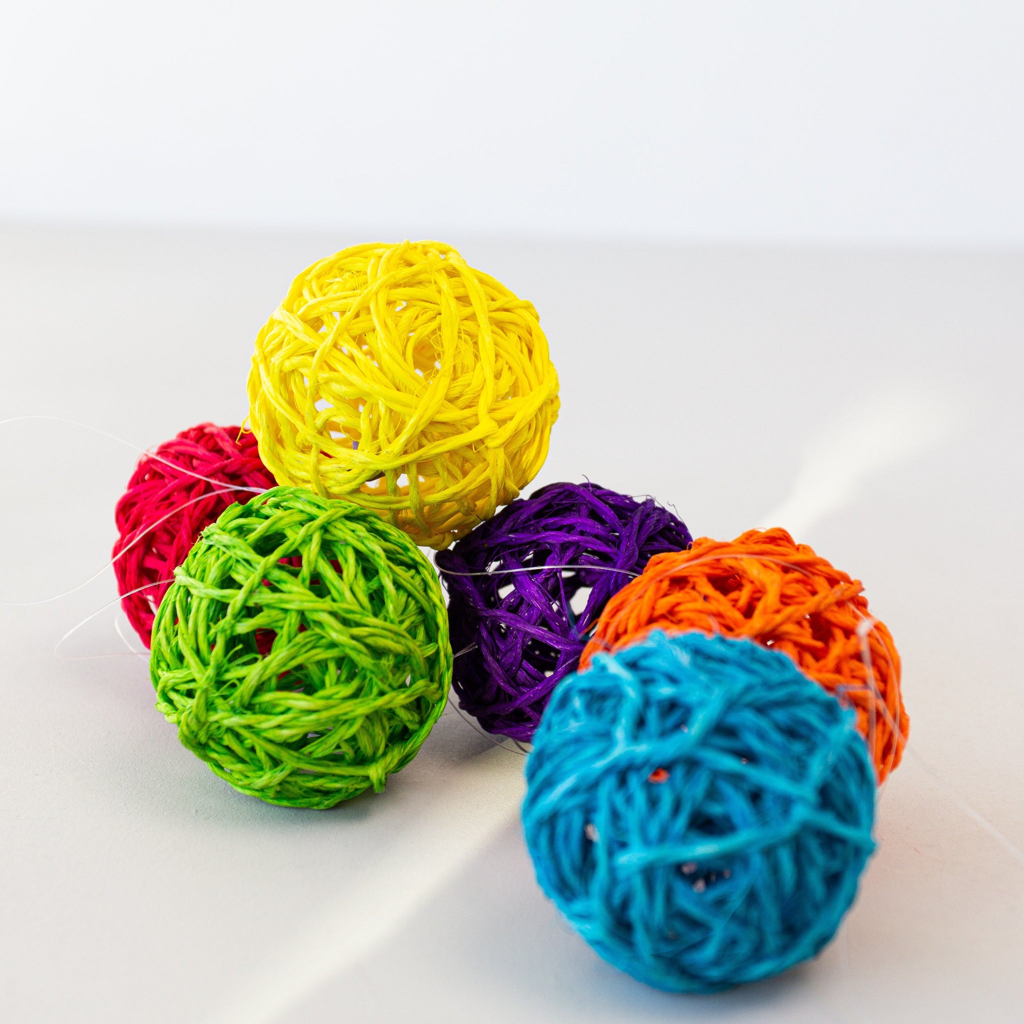 Colorful ball-shaped sisal ornaments on a white background
