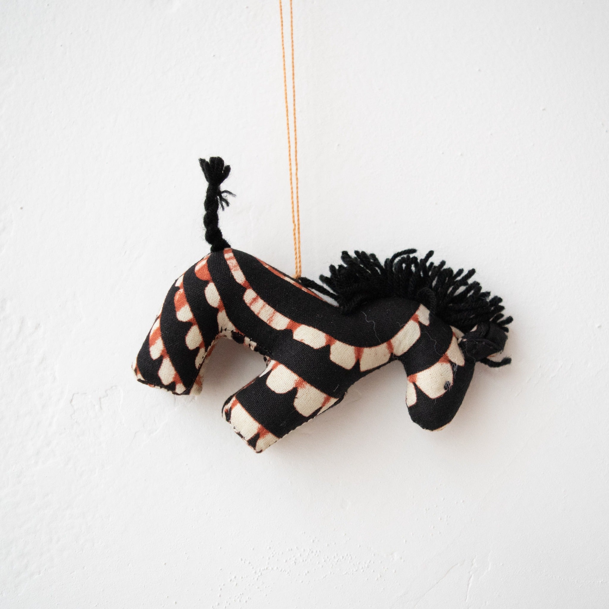 Stuffed zebra ornament hanging on white background