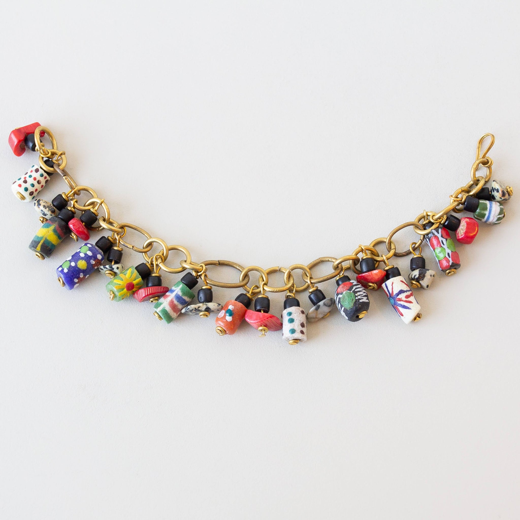 Colorful beaded bracelet with gold chain on a white background
