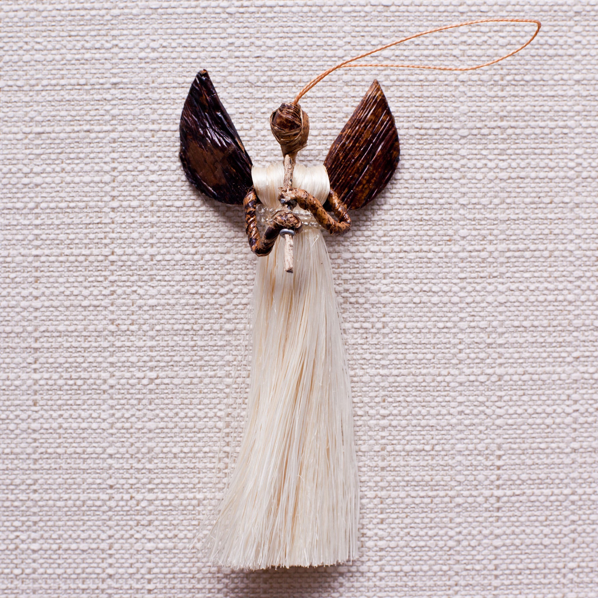 Sisal angel holding whistle on a white background