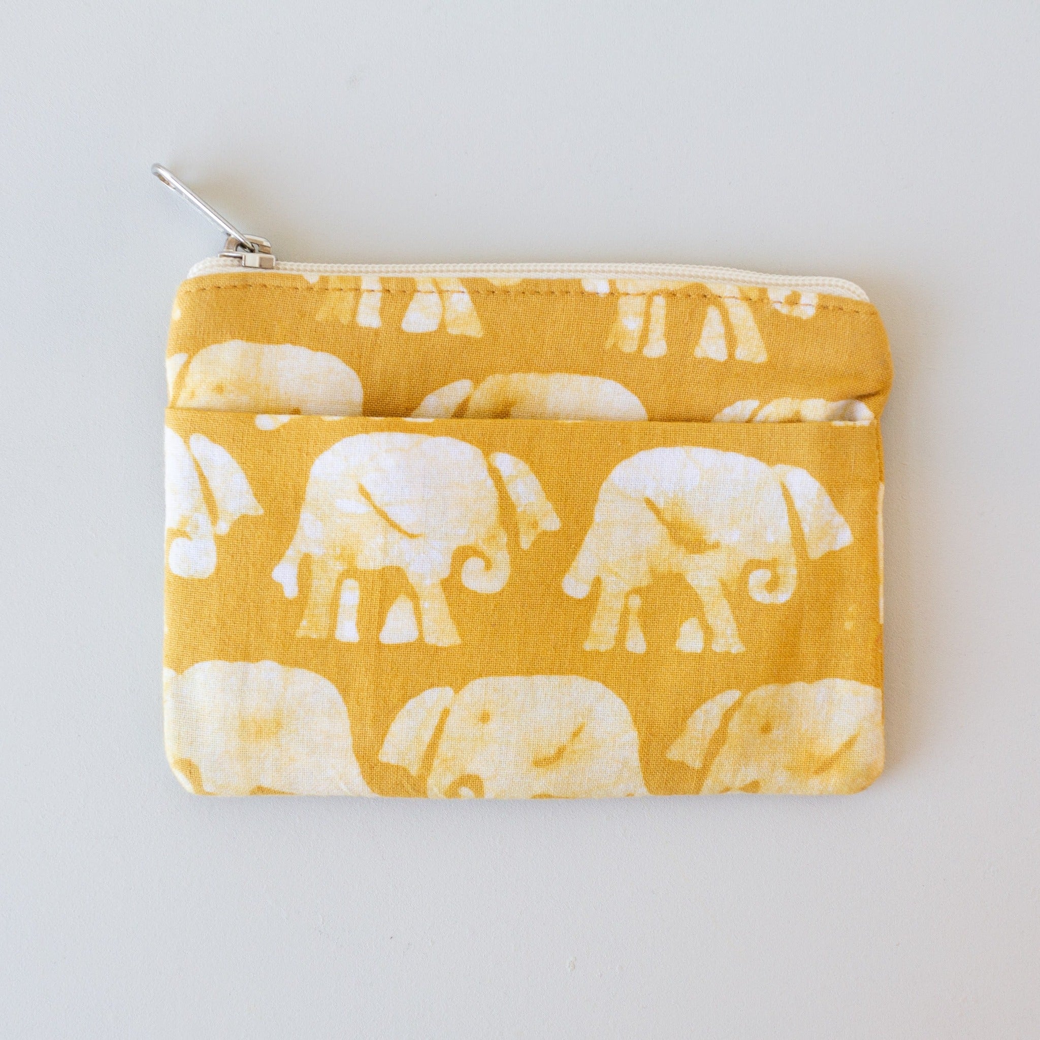 Yellow colored coin purse with an elephant pattern on a white background.