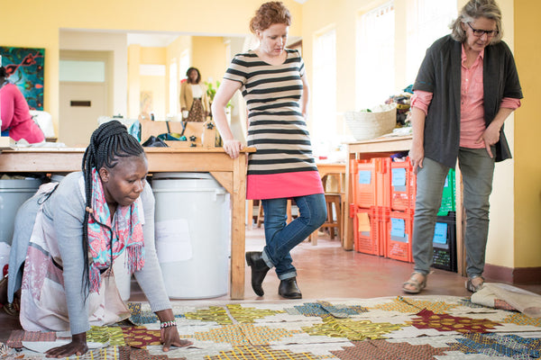 women in kenya, africa putting together pieces for a quilt