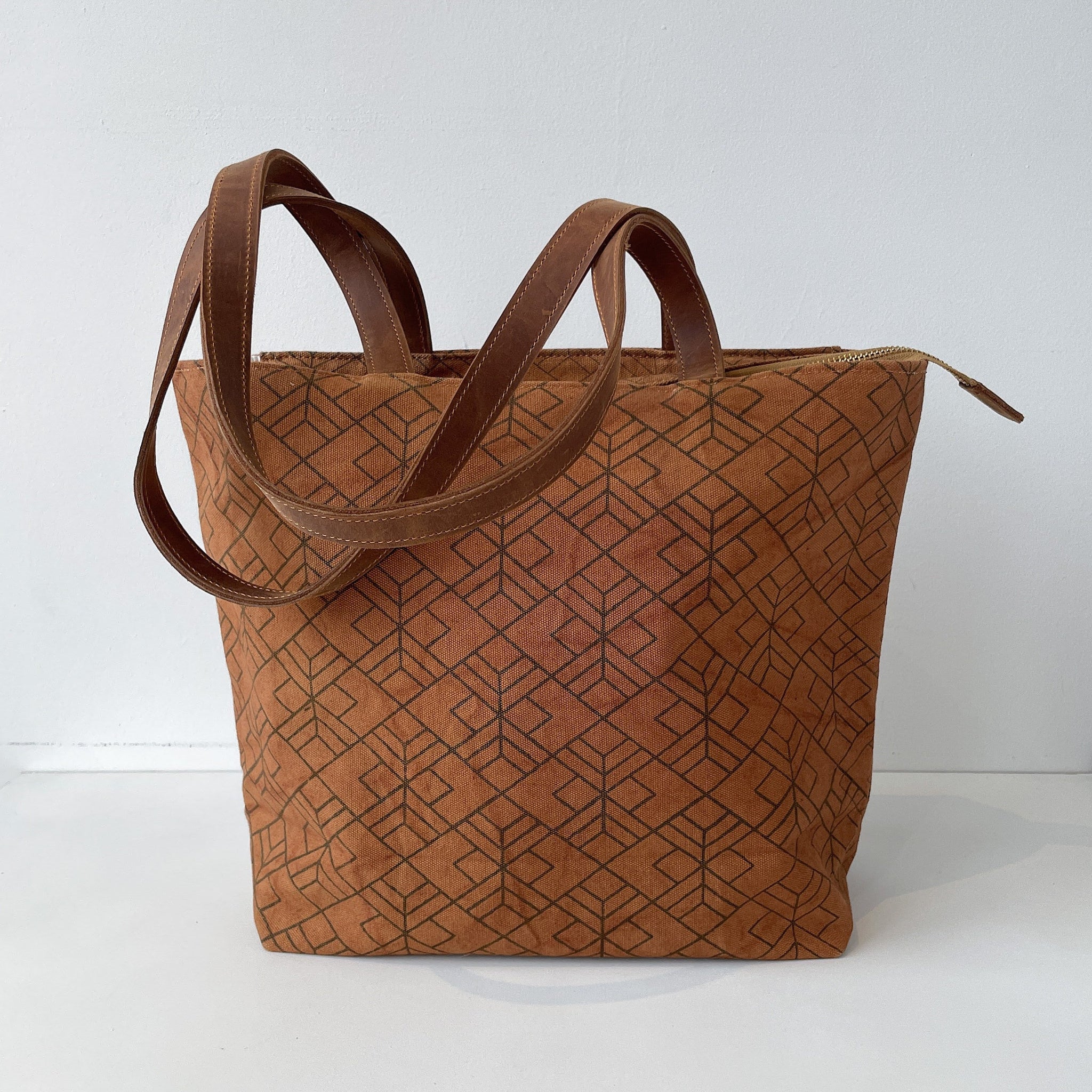 Brown tote bag with geometric pattern on a white background