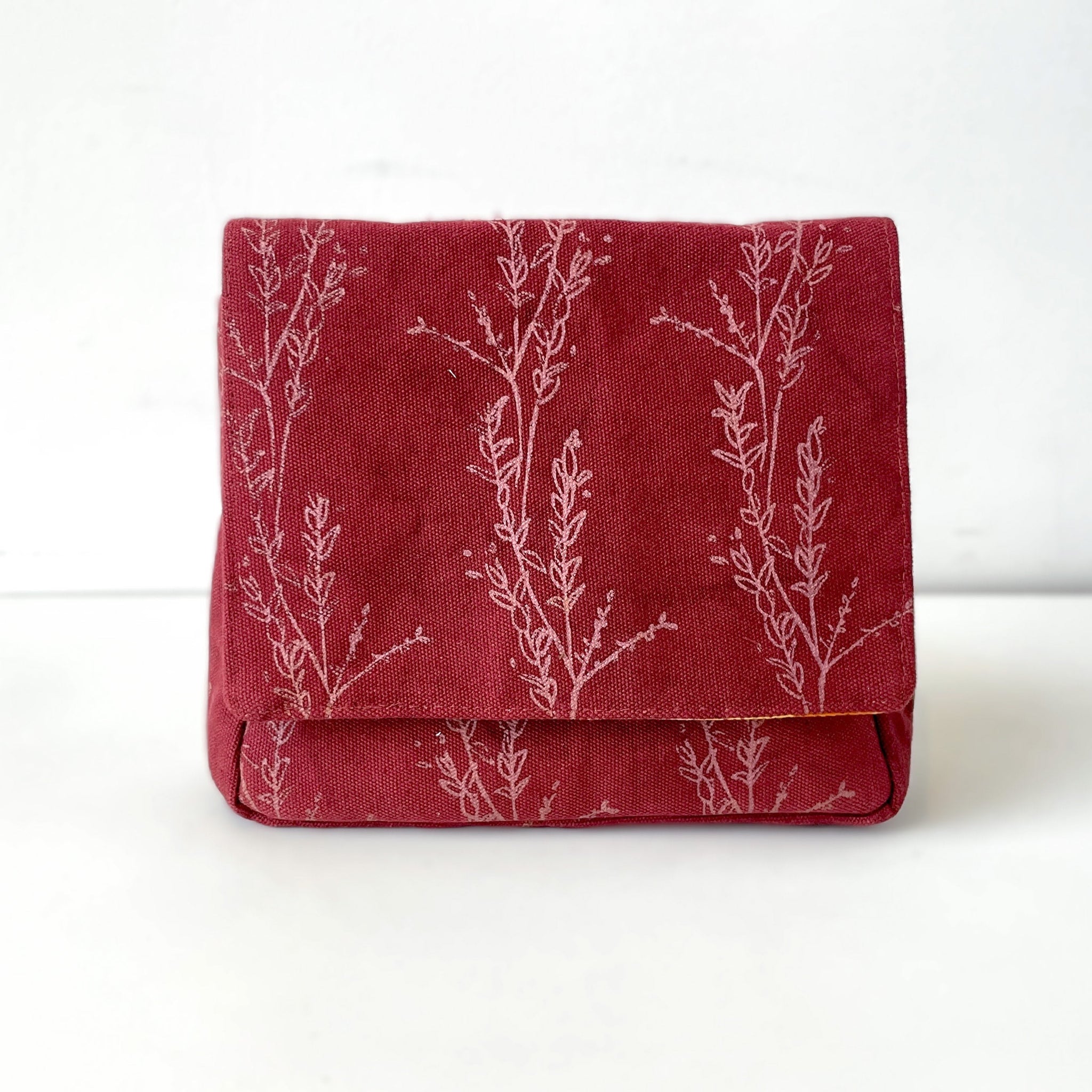 Red fabric wallet with white floral patterns on a white background