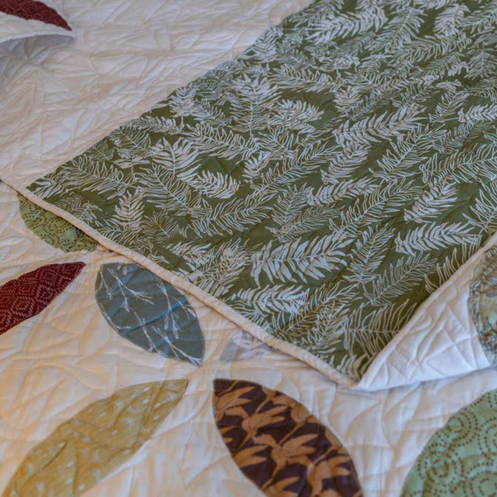Detail of a petal quilt with green fern backing.
