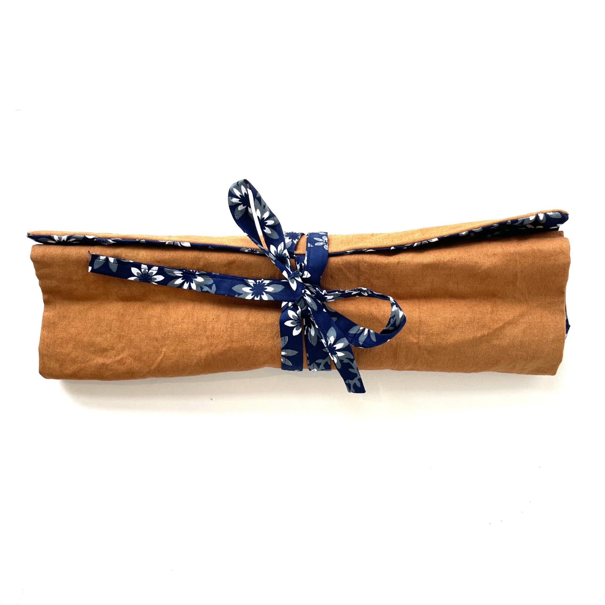 Brown fabric roll with a blue floral ribbon on a white background