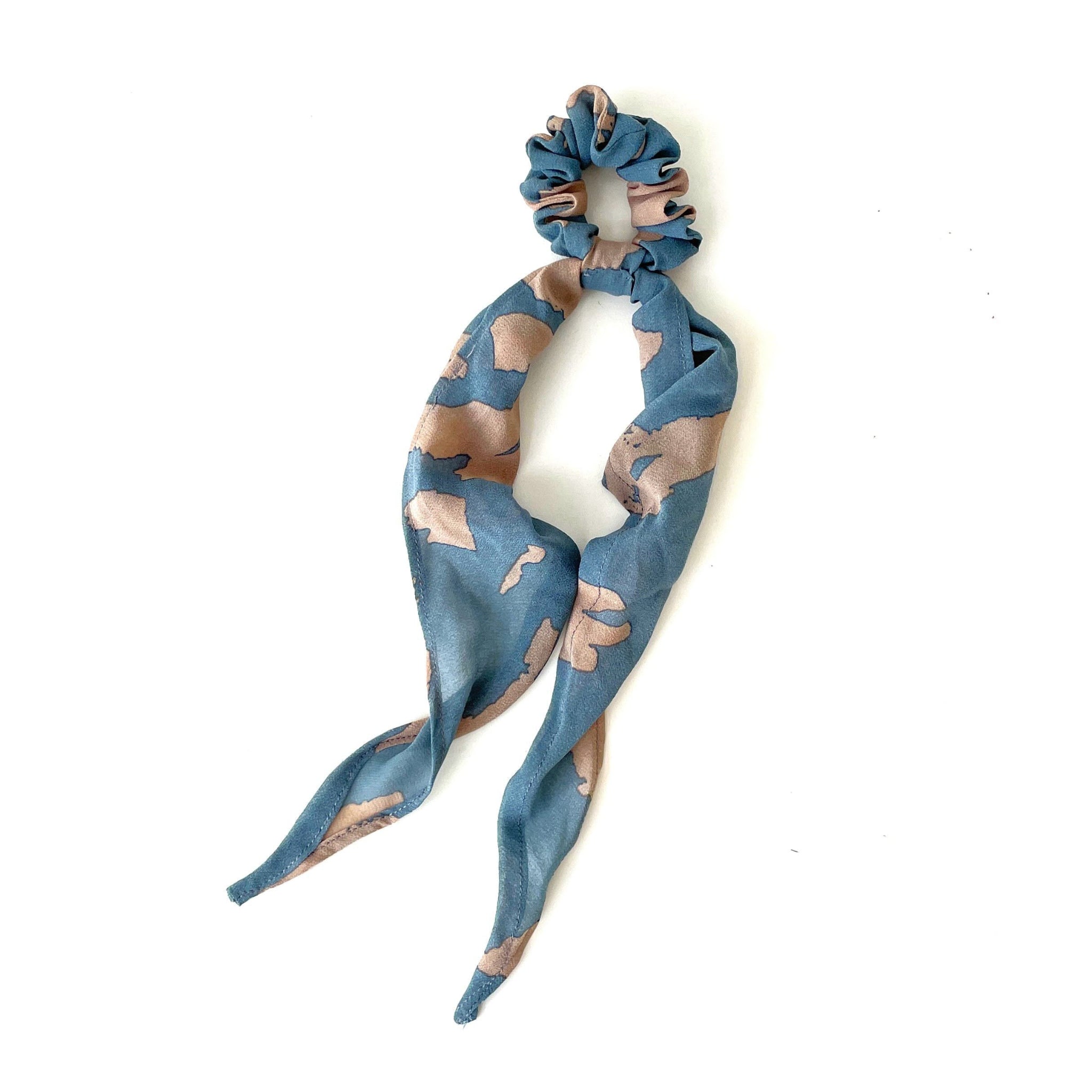 Blue and beige patterned hair scrunchie and scarf on a white background