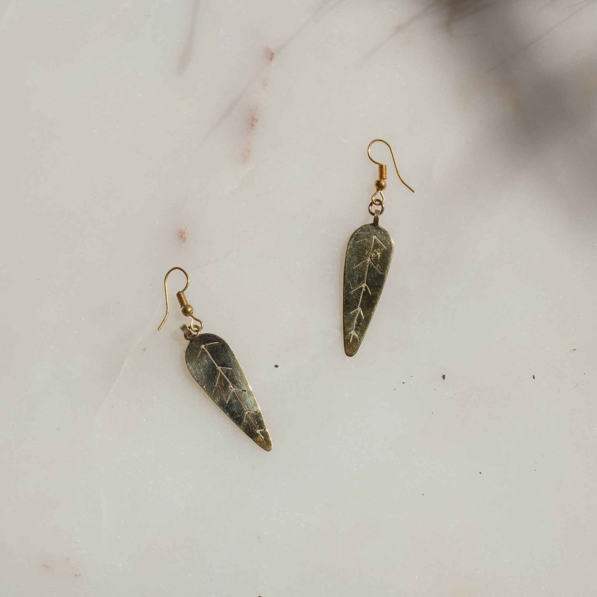 Pair of leaf-shaped earrings on a light background