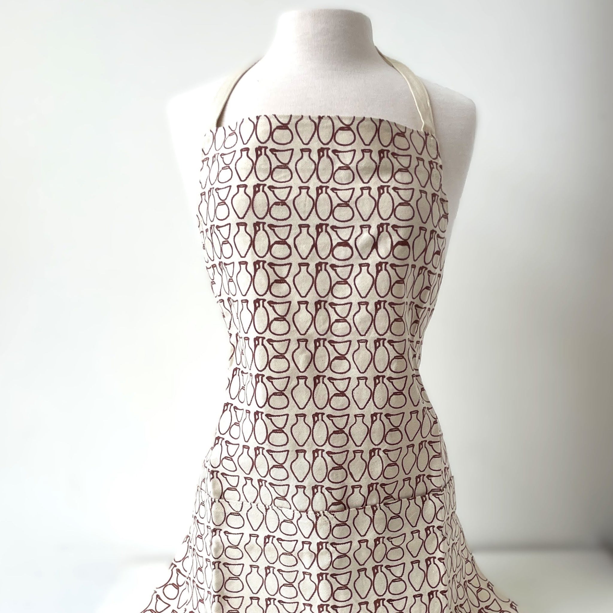 Patterned apron on a mannequin against a white background