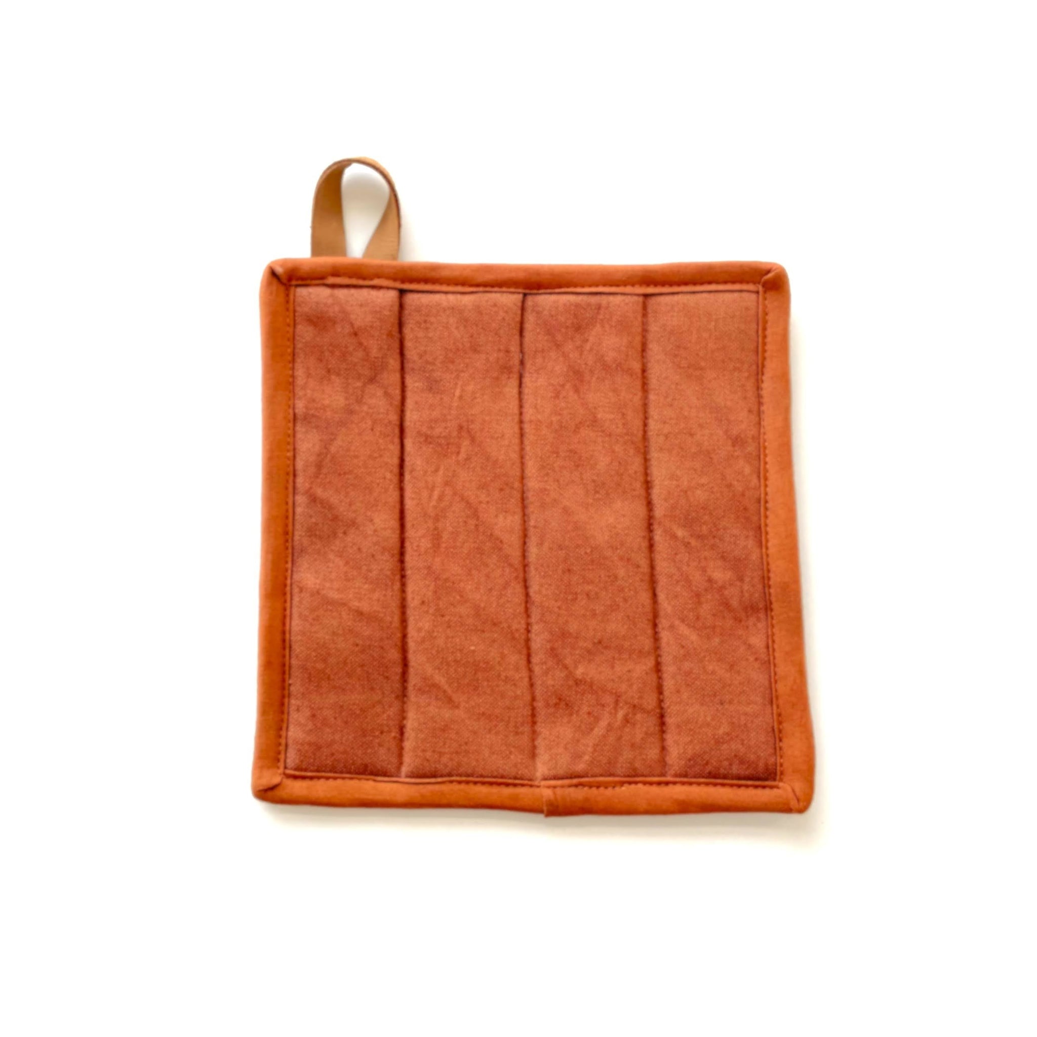 Copper colored potholder with a leather strap on a white background