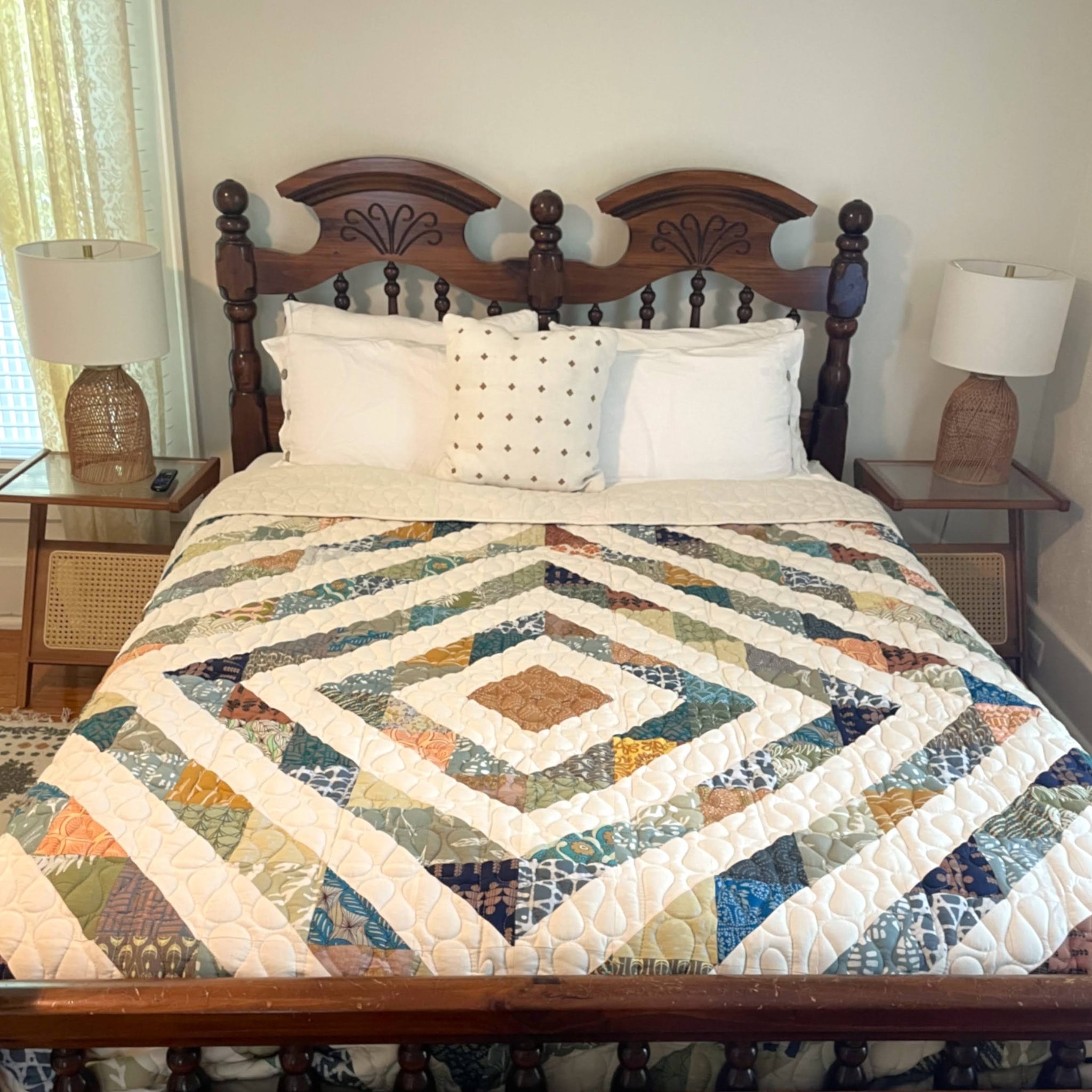 Bed with a patchwork quilt and wooden headboard in a bedroom setting.