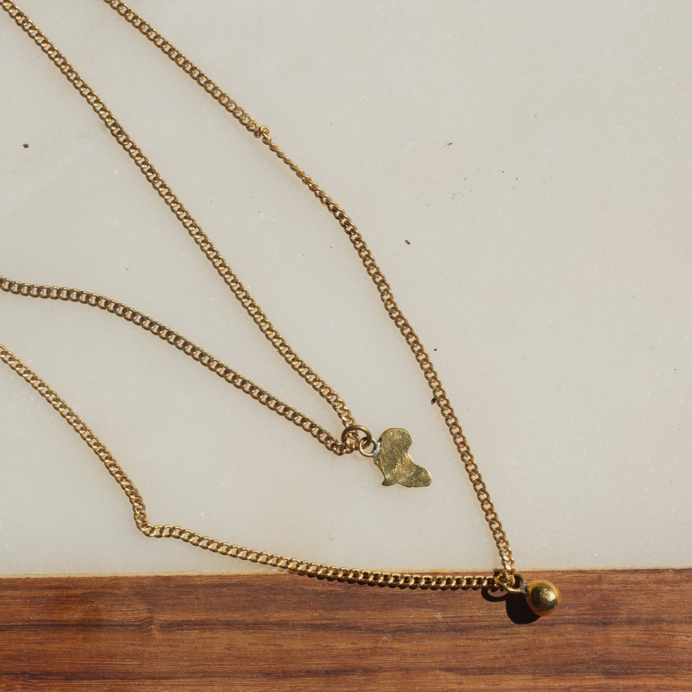 Brass necklace with Africa-shaped pendant on a wooden surface
