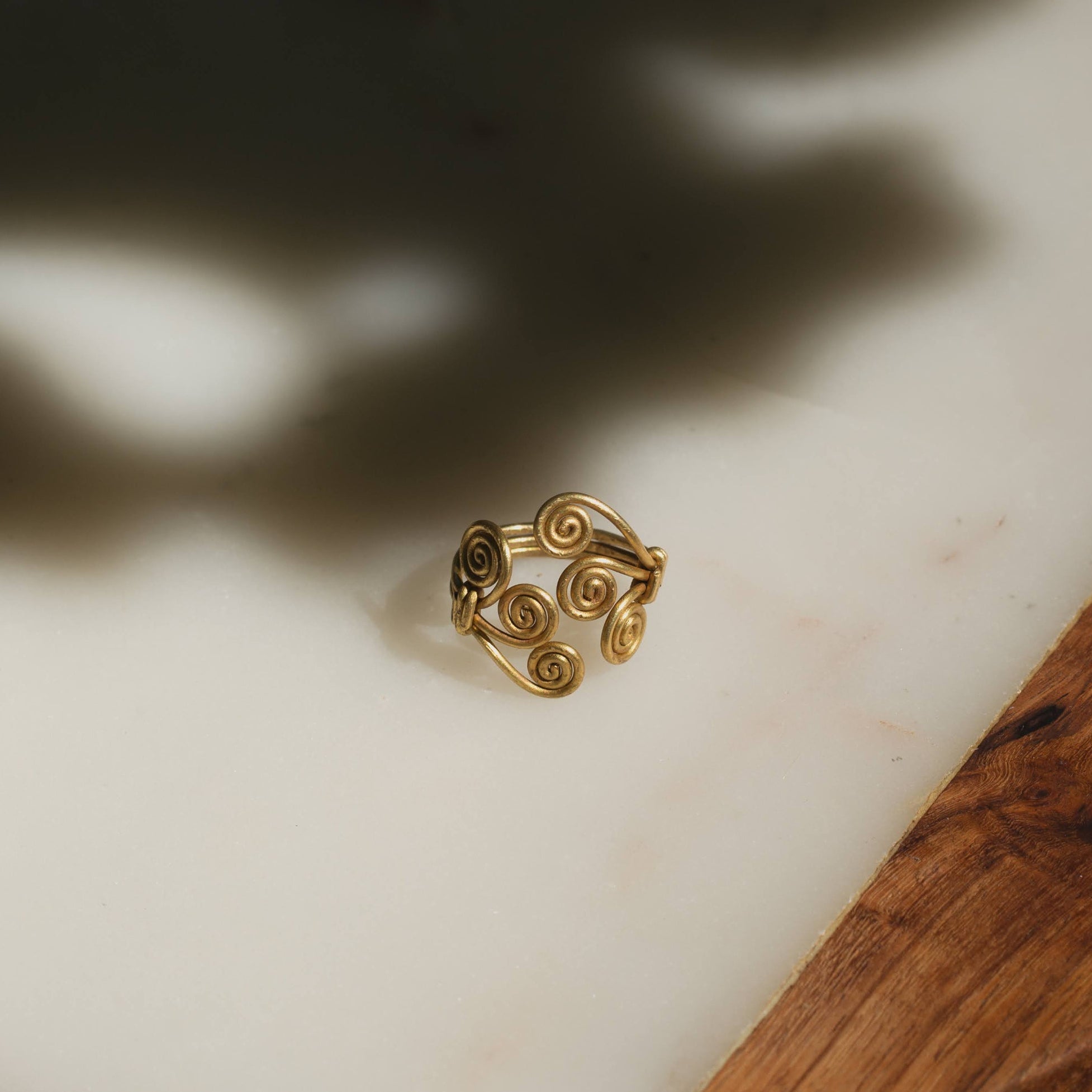 Adjustable brass ring in spiral design on a light background