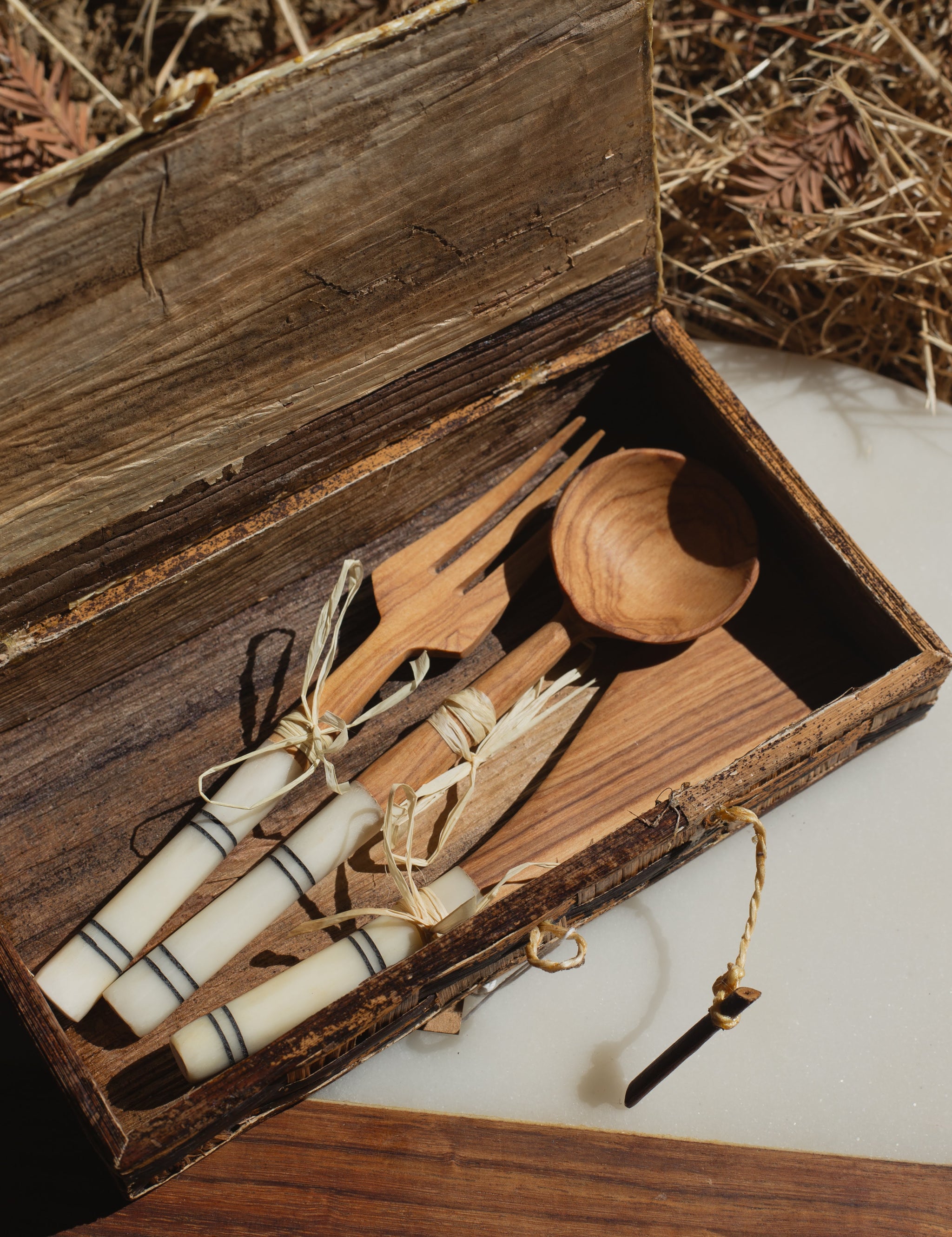 Wooden cutlery set with a banana leaf box on a rustic background