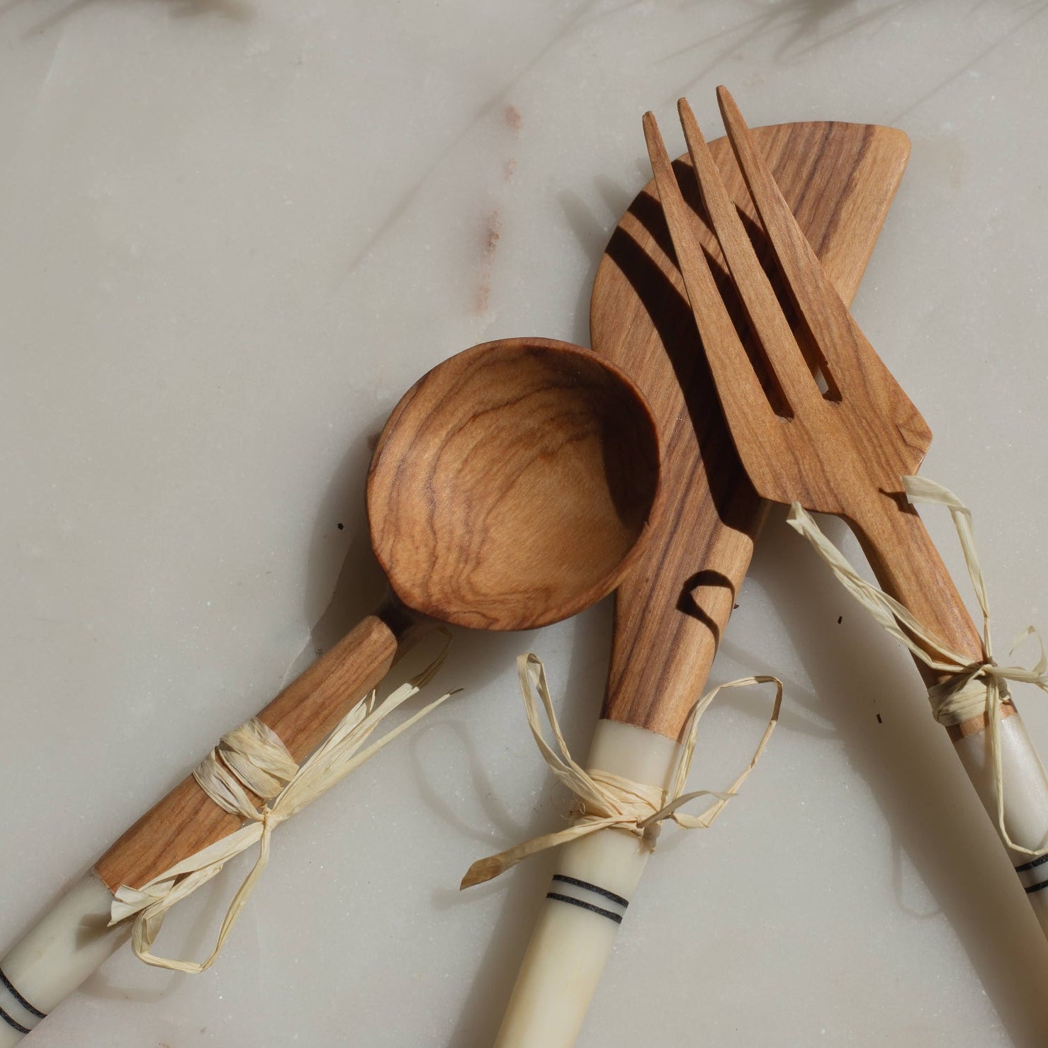 Wooden spoon, fork, and knife set on a light background
