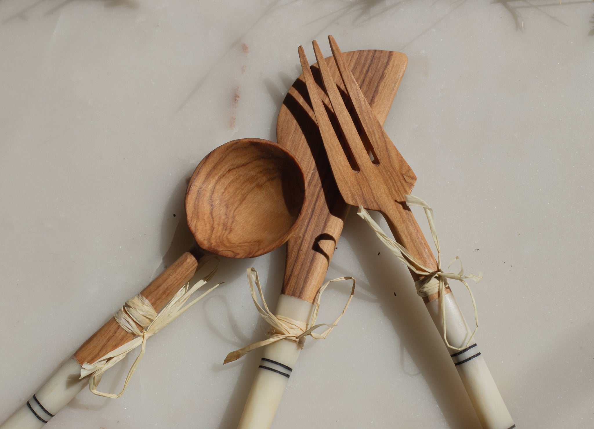 Wooden spoon, fork, and knife set on a light background