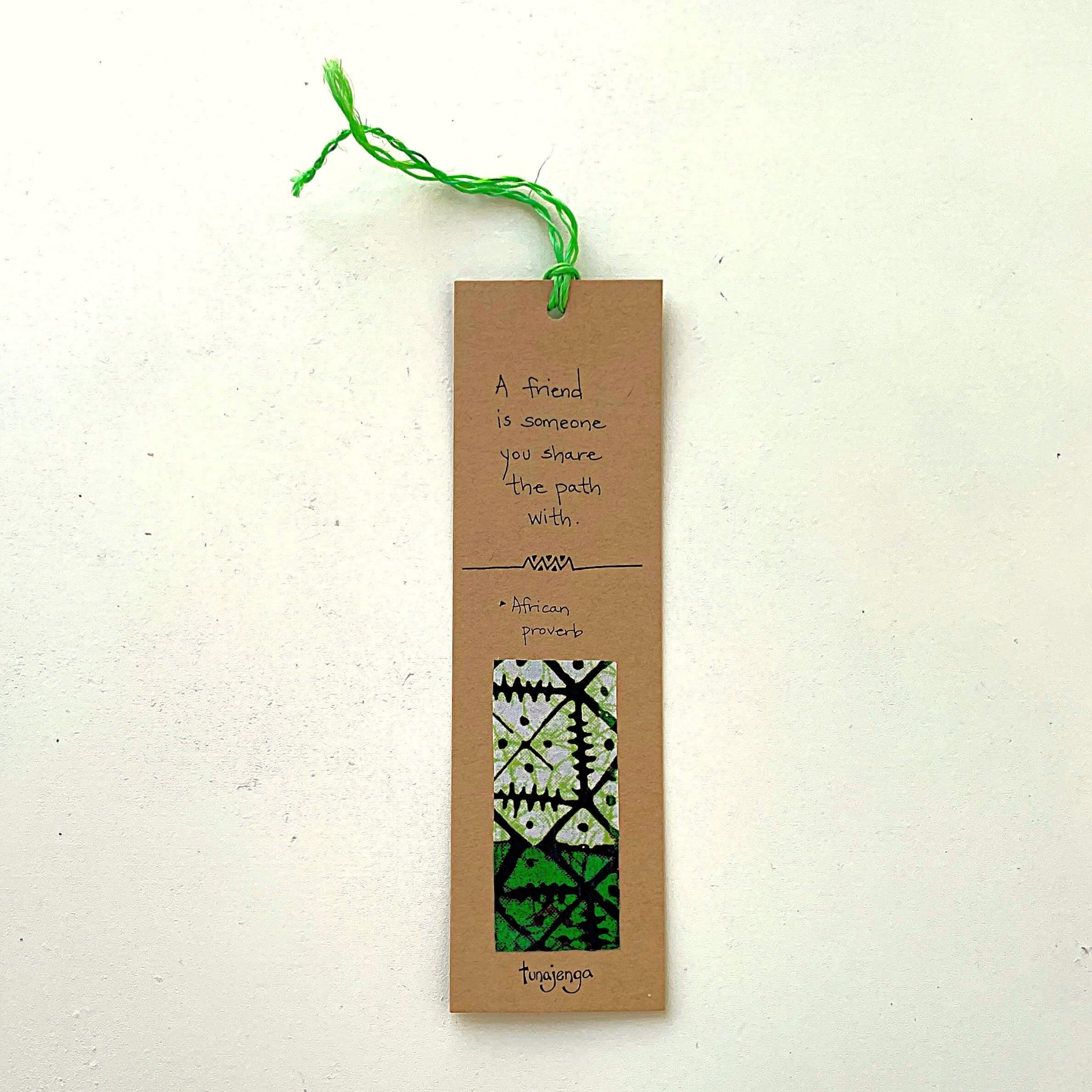 Bookmark with text and green thread on a white background
