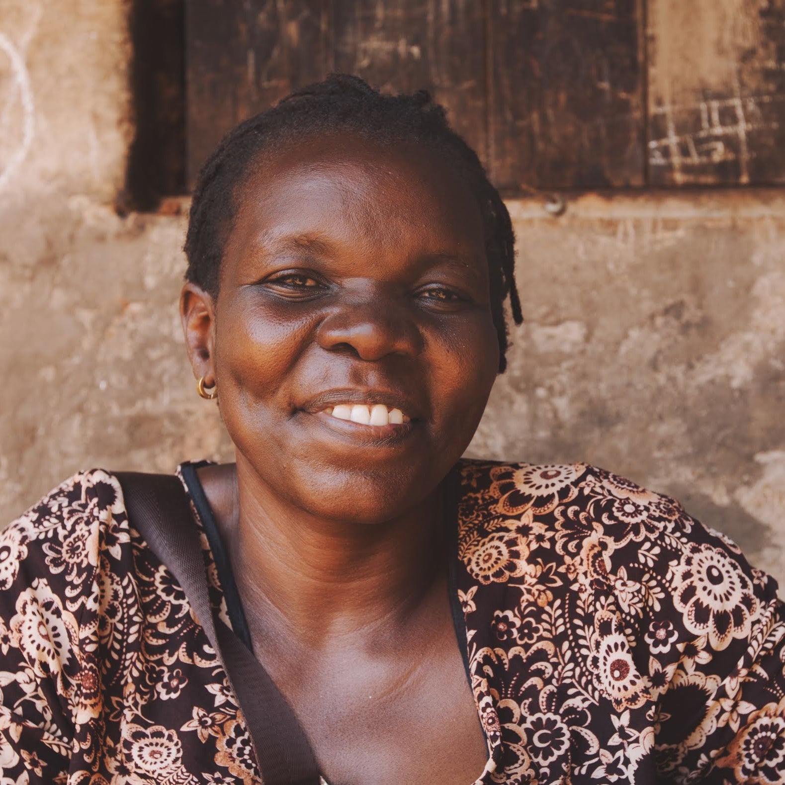 Woman (Simprosa) smiling in front of a textured wall
