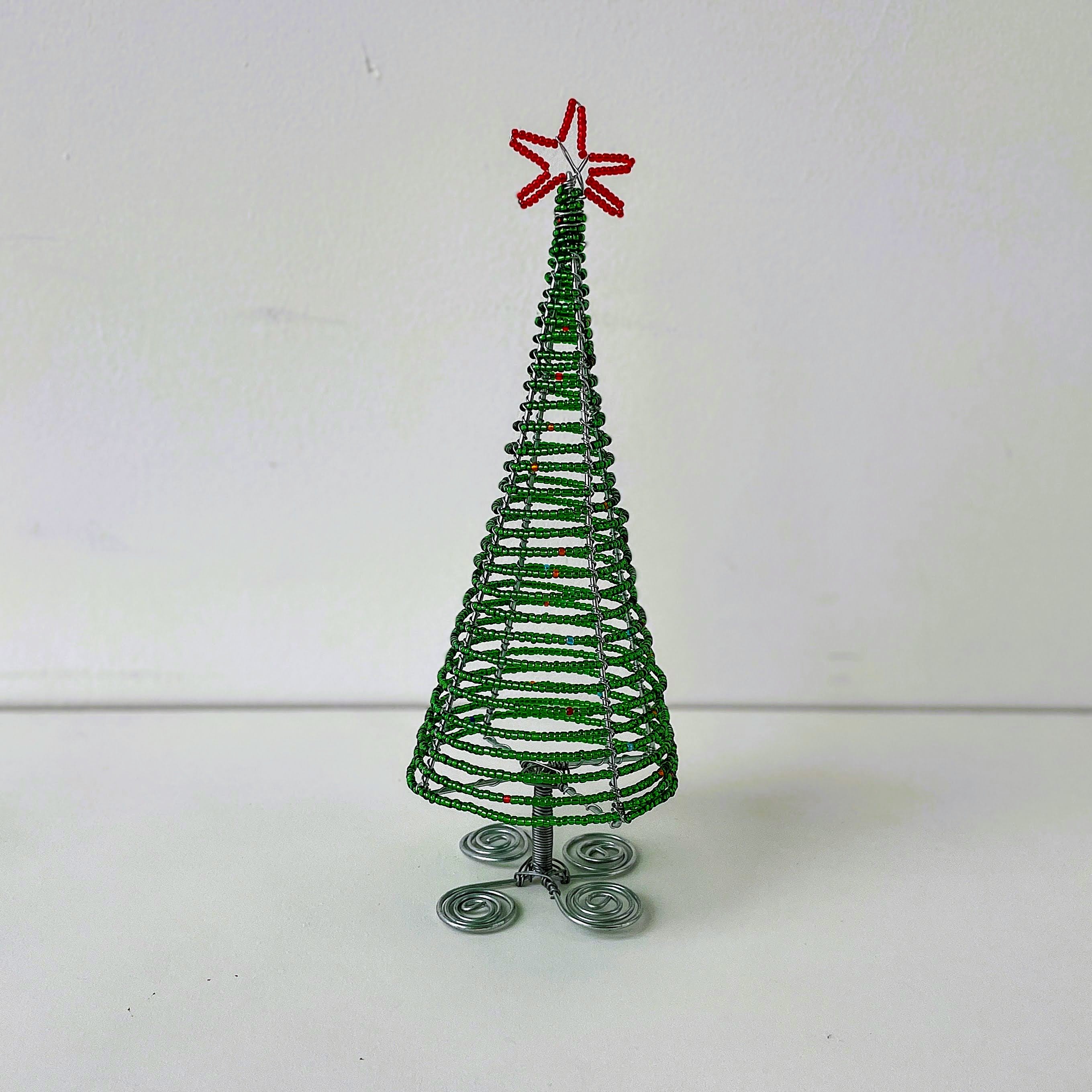 Green wire Christmas tree with a red star on a white background