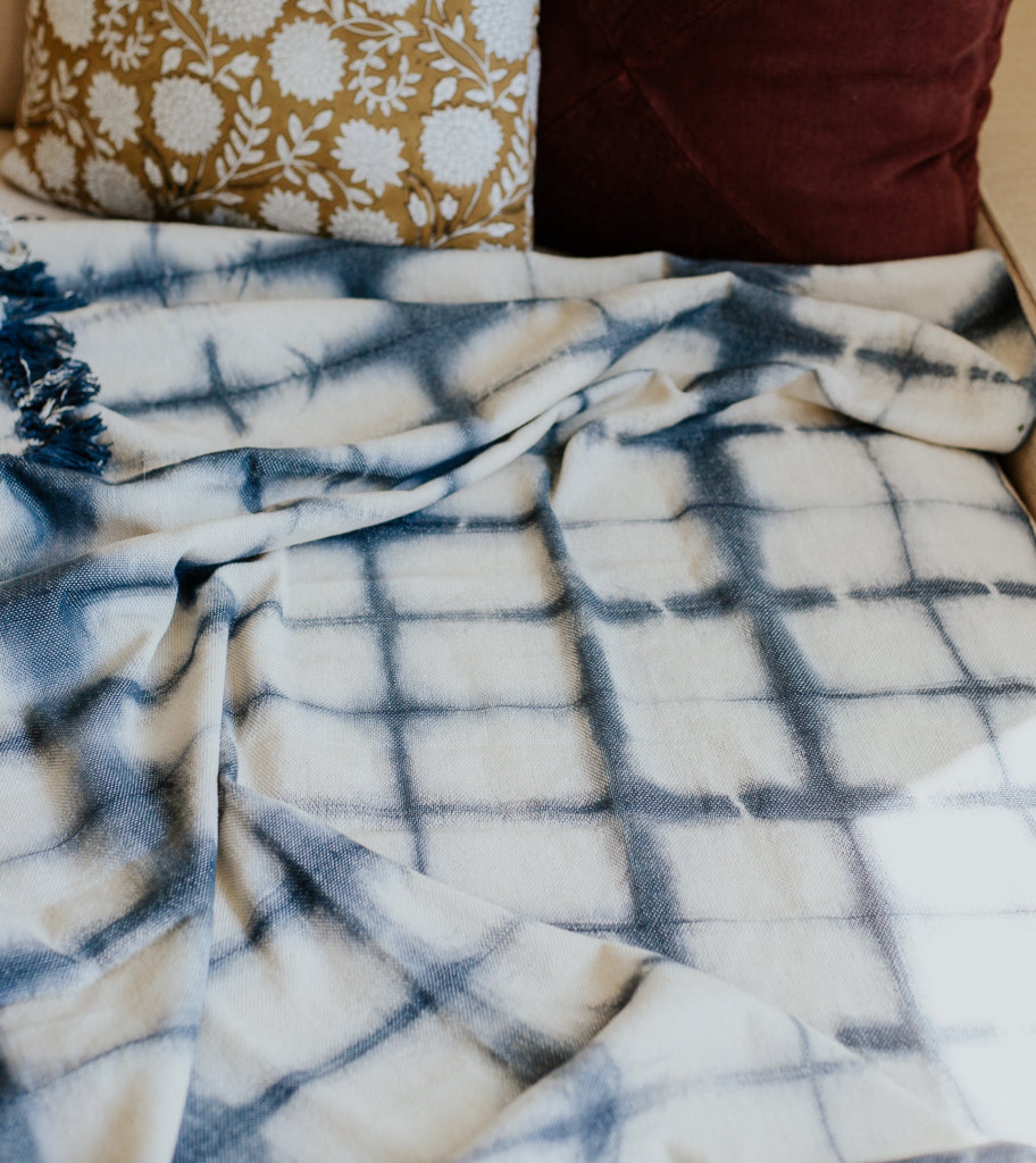 Plaid blanket with blue and white pattern draped over a surface